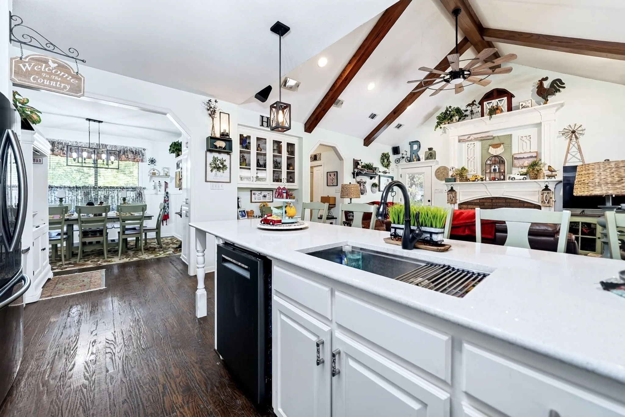 Spacious kitchen island featuring a white countertop and undermount sink with a matte black faucet