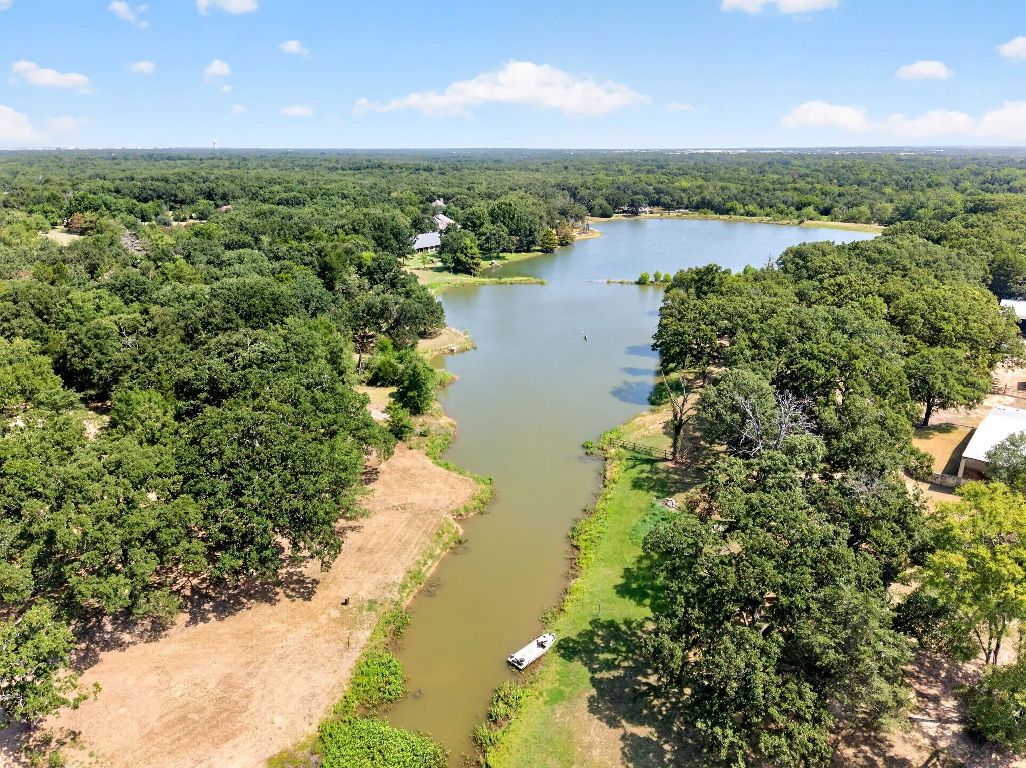 Expansive waterfront property featuring a scenic river frontage bordered by mature hardwood trees
