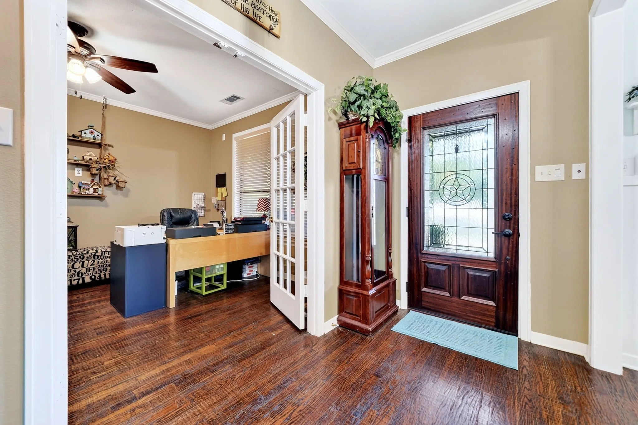 Hardwood flooring extending from the entryway into an adjoining room