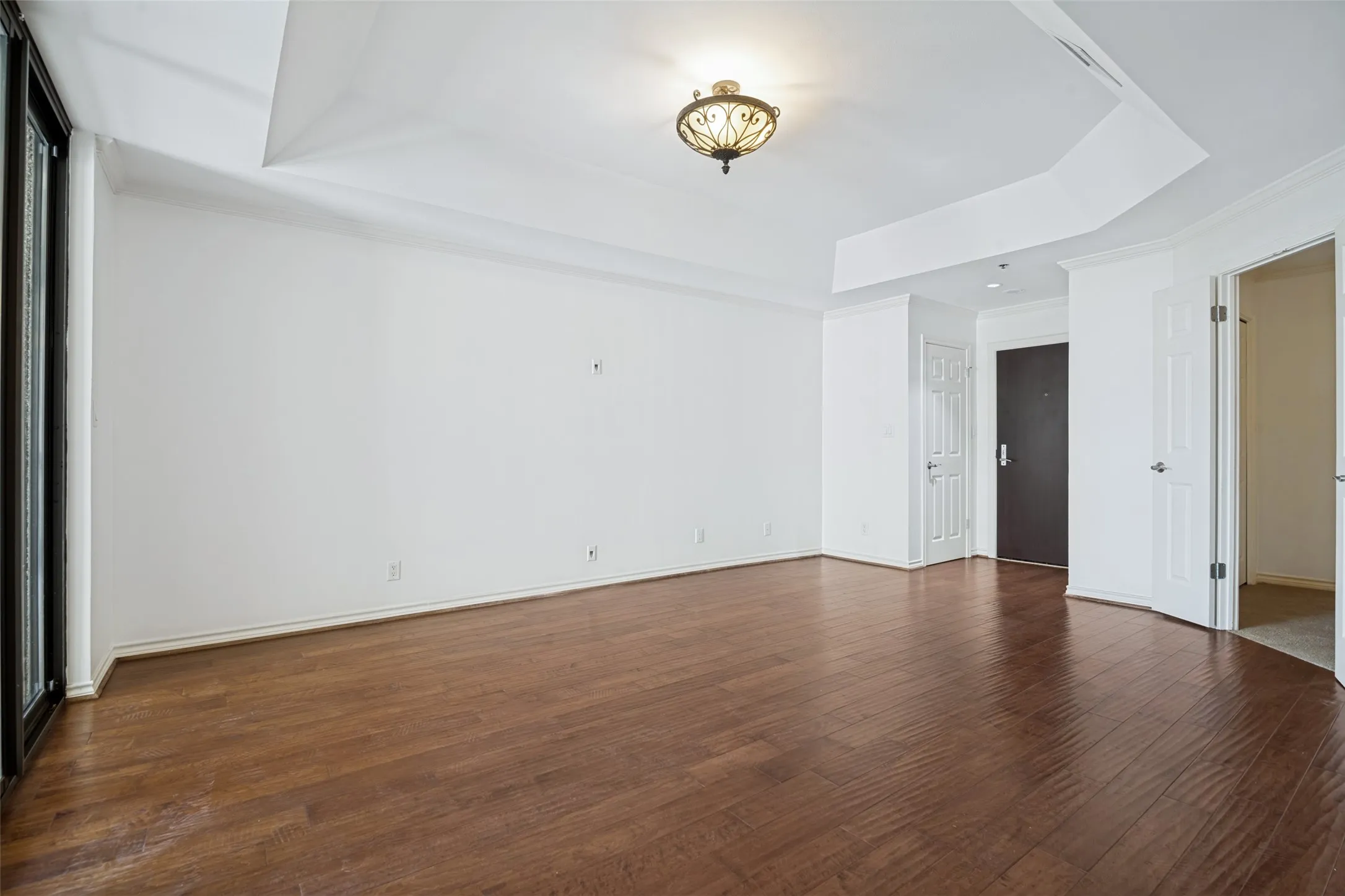 The living space looking back to the front door and large foyer closet with a bedroom to the right.