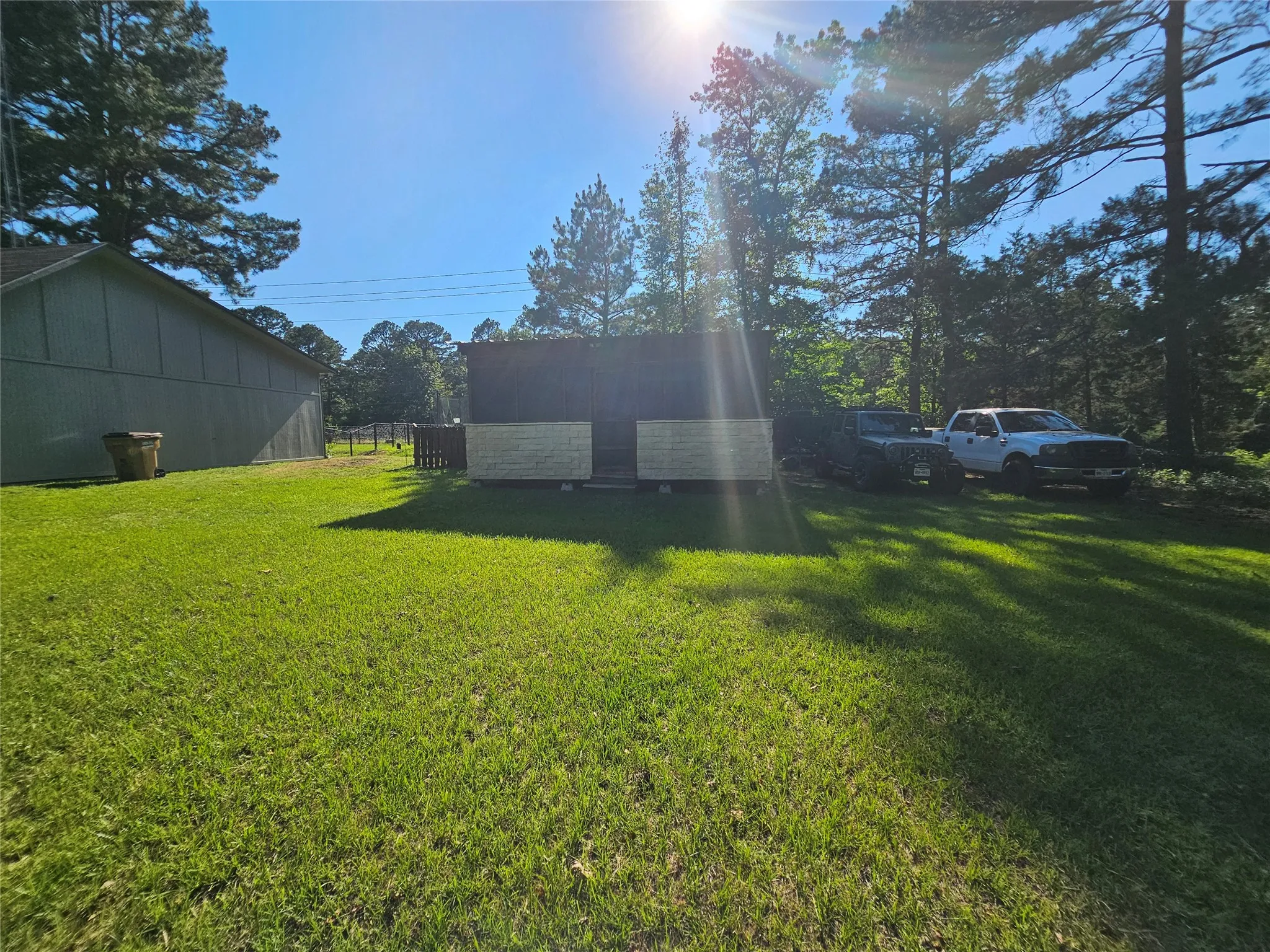 Expansive green lawn with mature trees providing natural shading