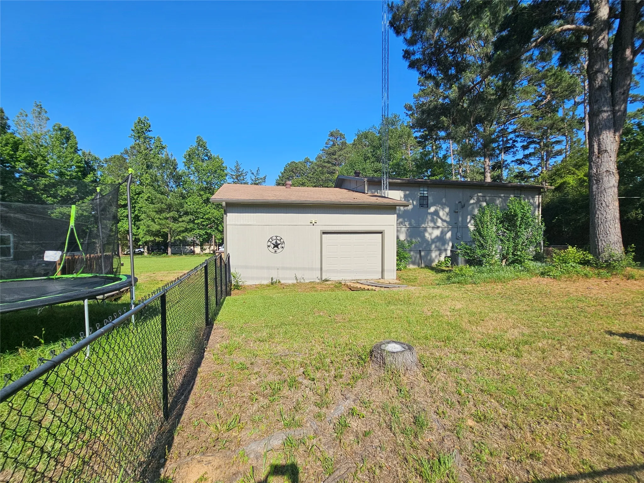 Detached garage structure featuring a single garage door and exterior wall decor