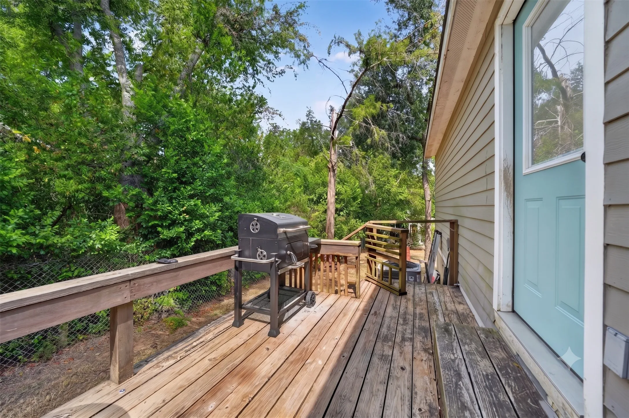 Expansive wood deck with a built-in bench, offering ample outdoor living space