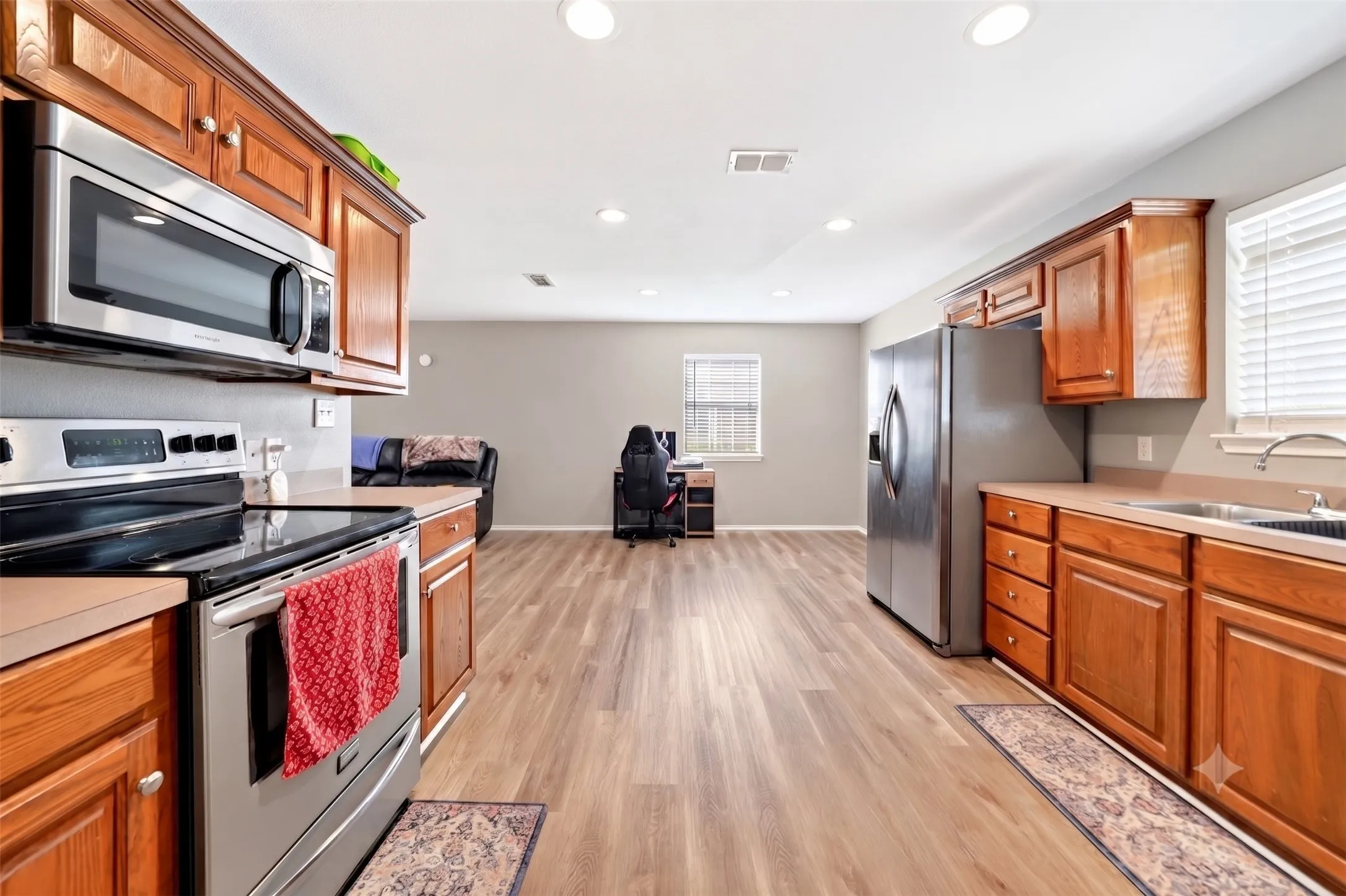 Kitchen featuring wood cabinetry, stainless steel appliances, and a double basin sink