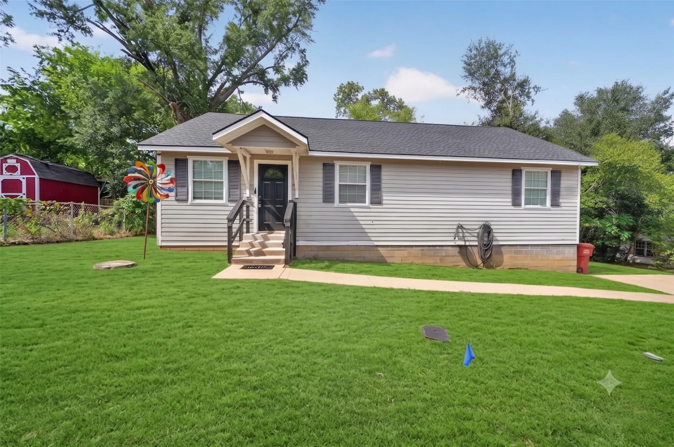Light gray siding exterior with a dark roof and black shutters