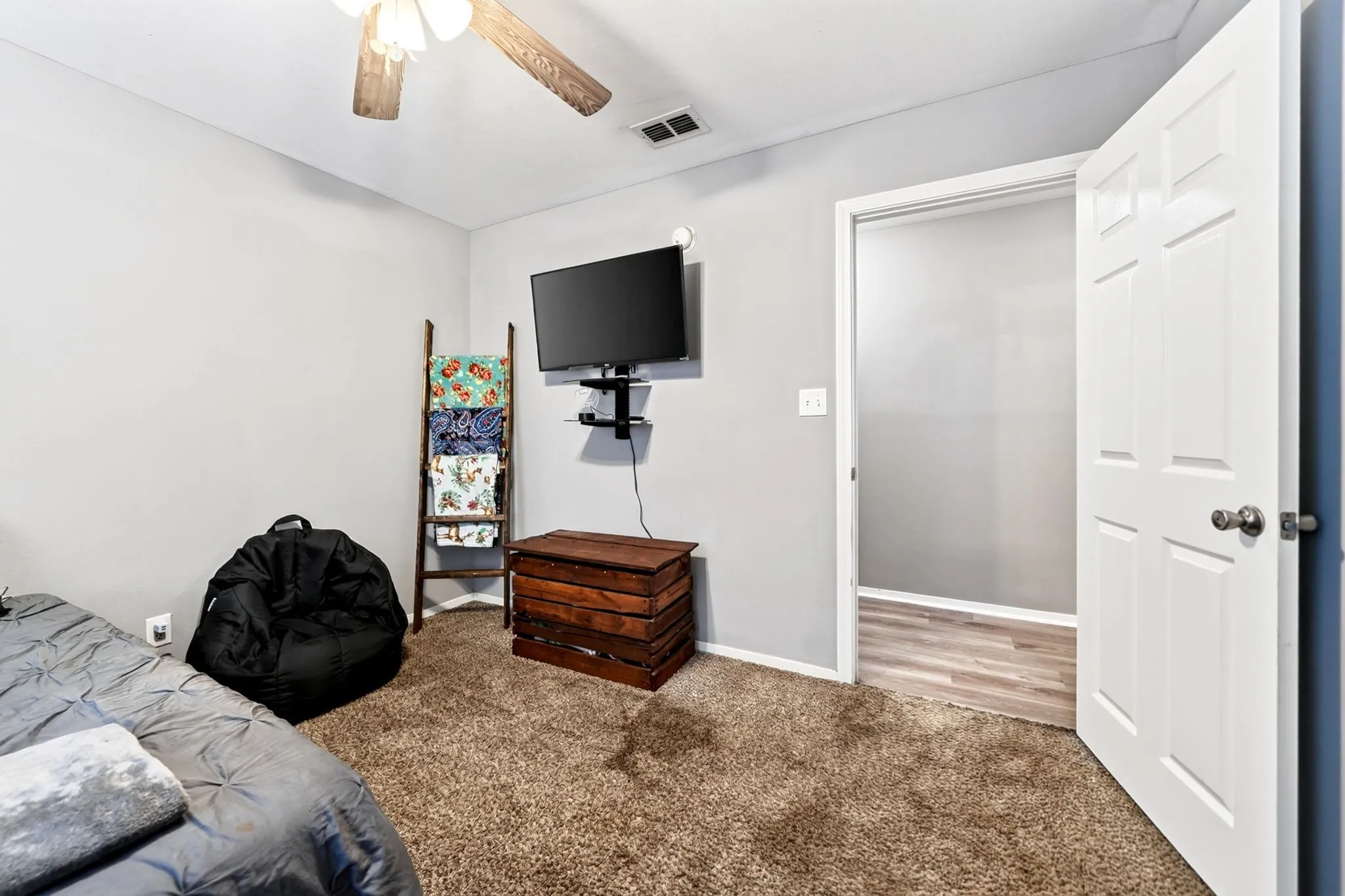 Bedroom featuring neutral wall paint, brown carpet flooring, and a ceiling fan with light fixture