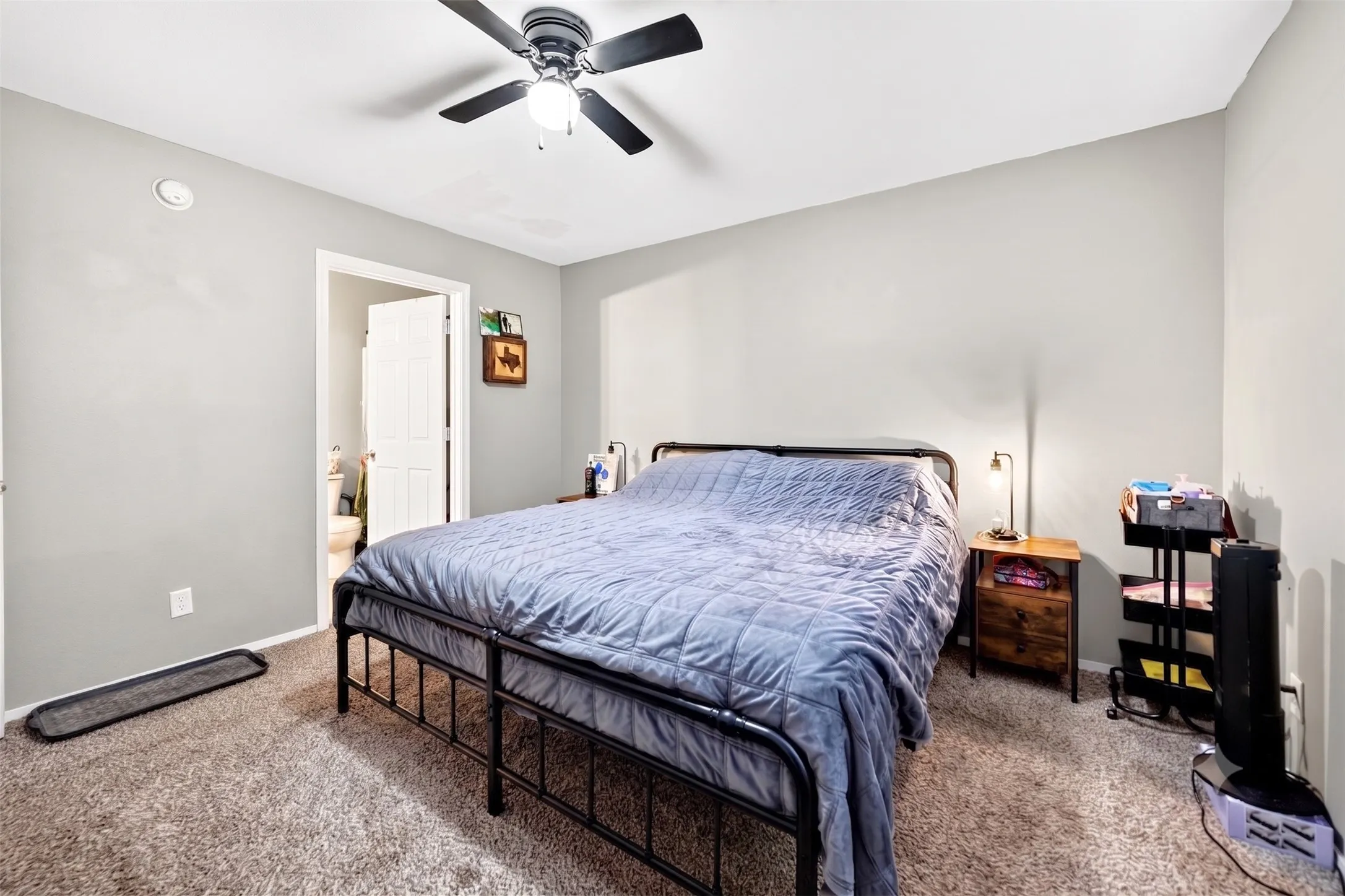 Bedroom featuring neutral-toned walls, carpet flooring, and a ceiling fan with integrated lighting