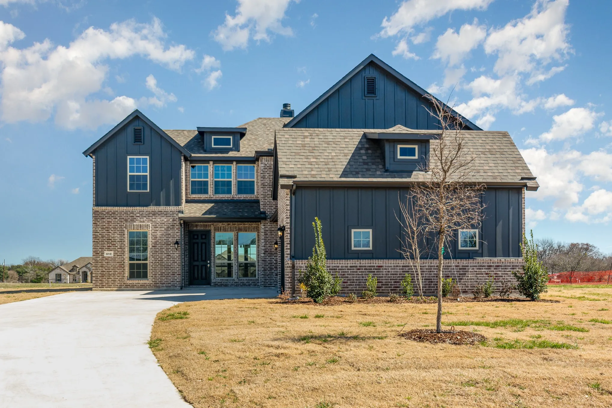 Modern exterior featuring a dark brick facade and vertical panel siding