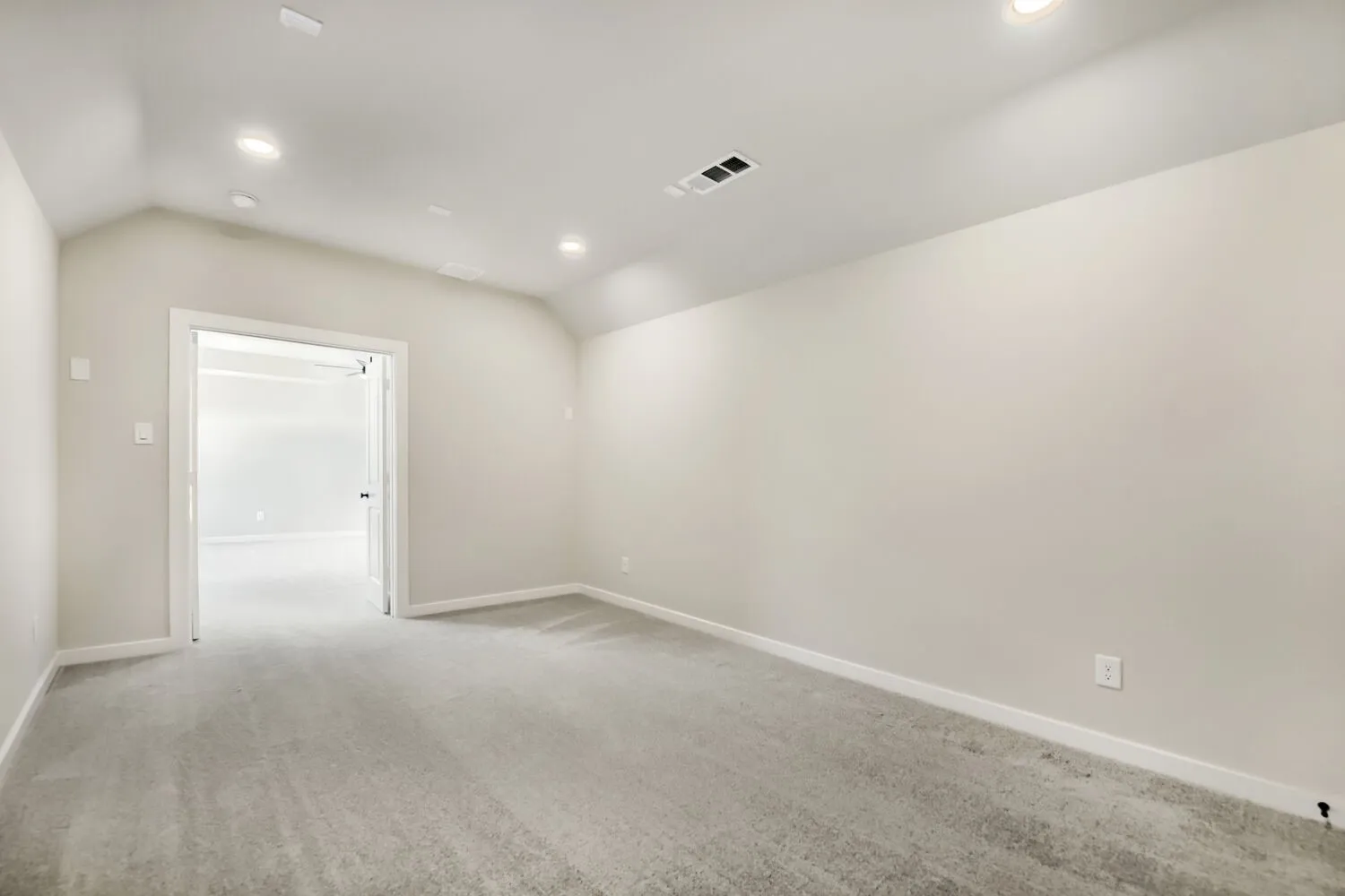 Vaulted ceiling, recessed lighting, neutral wall tones, gray carpeting, and white trim