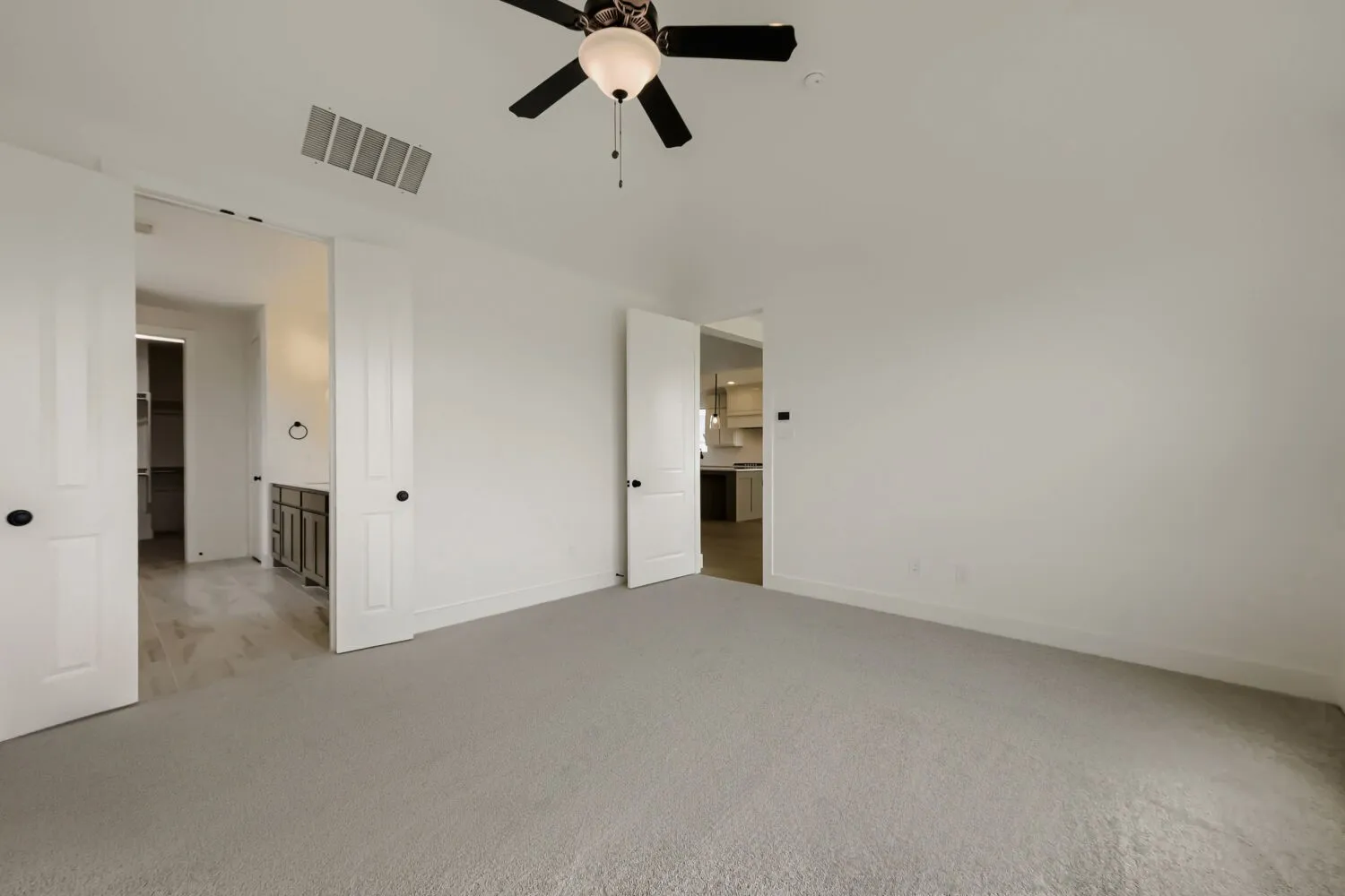 Neutral-toned carpeting, white walls, and a ceiling fan with integrated lighting