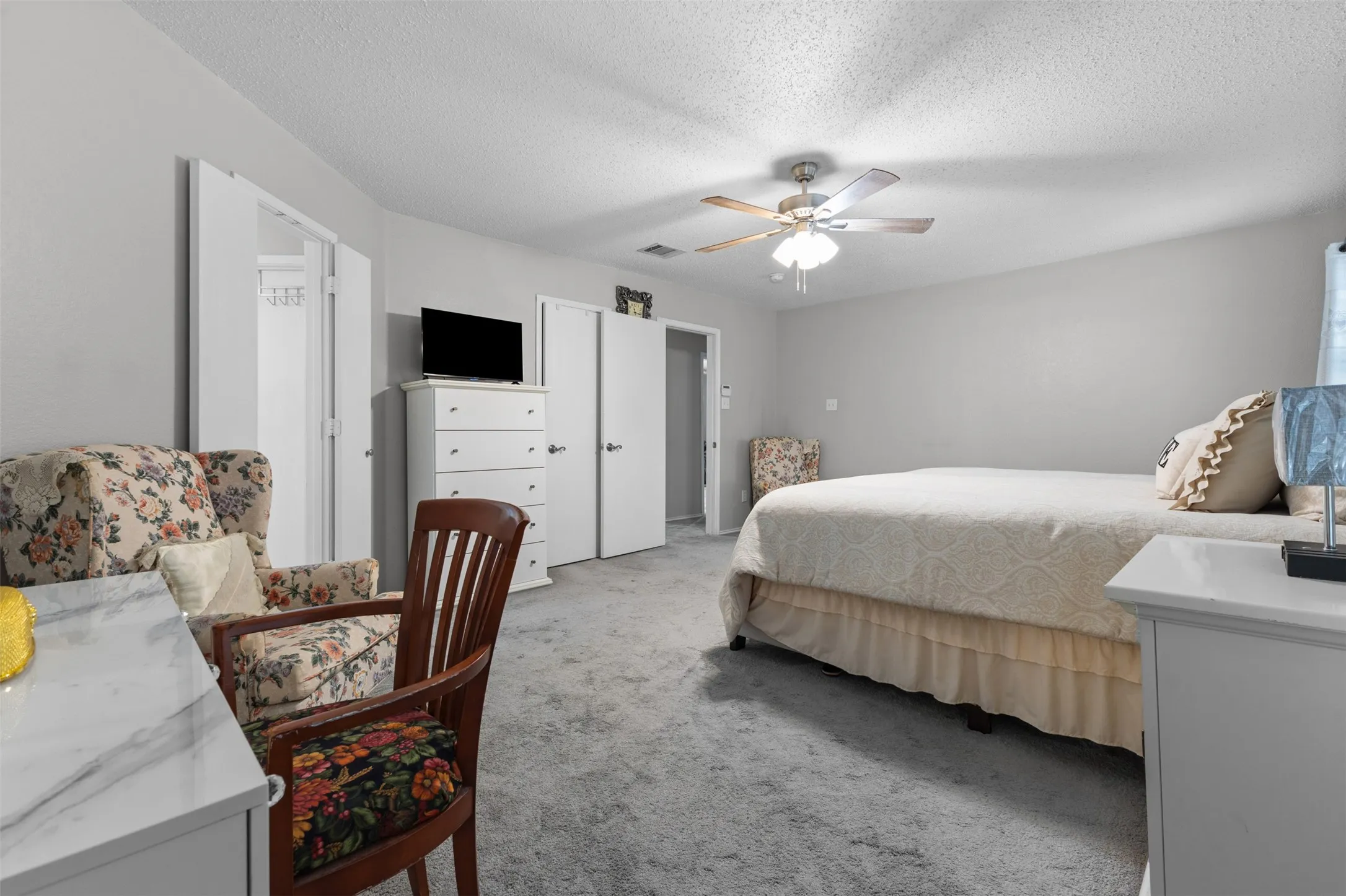 Spacious room featuring neutral painted walls and gray carpeting