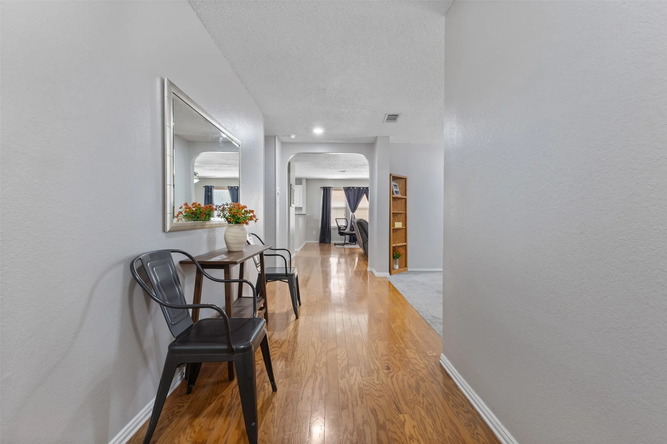 Hallway featuring wood-finish flooring and light gray painted walls