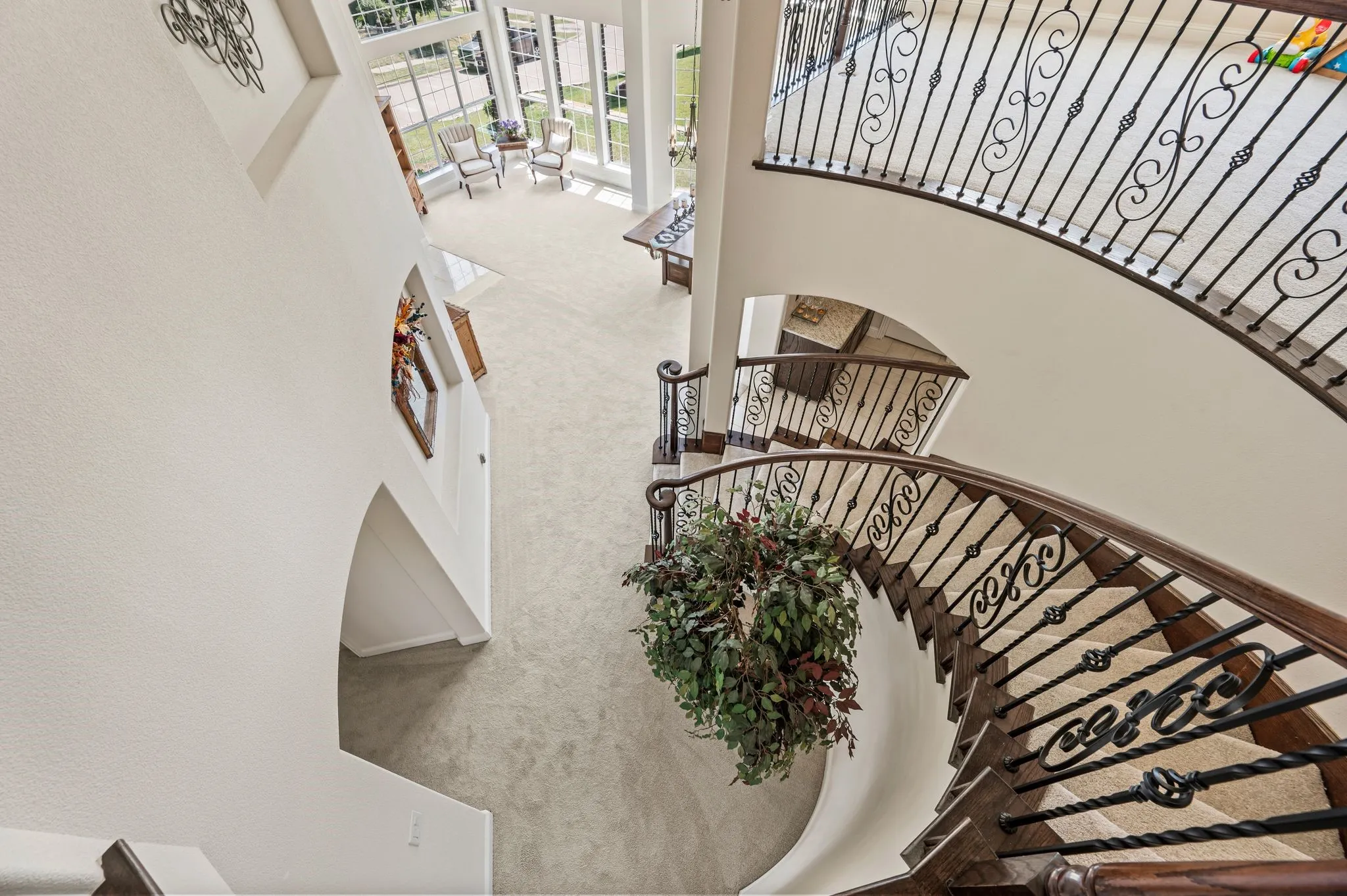Dramatic view from the upstairs overlooking the grand foyer, showcasing elegant wrought-iron railings & soaring ceilings.