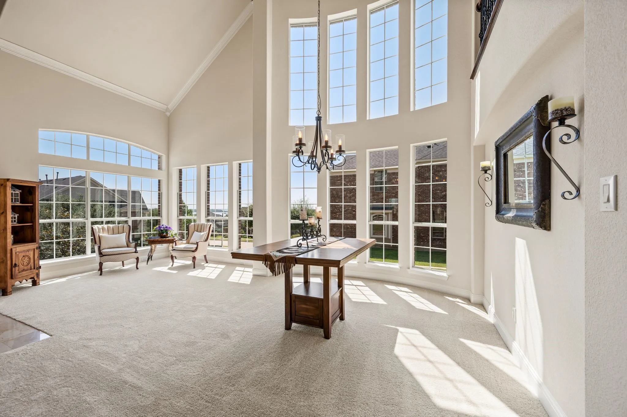 Bright & inviting formal living area with breathtaking two-story 20' ceilings, oversized windows & endless possibilities for entertaining.