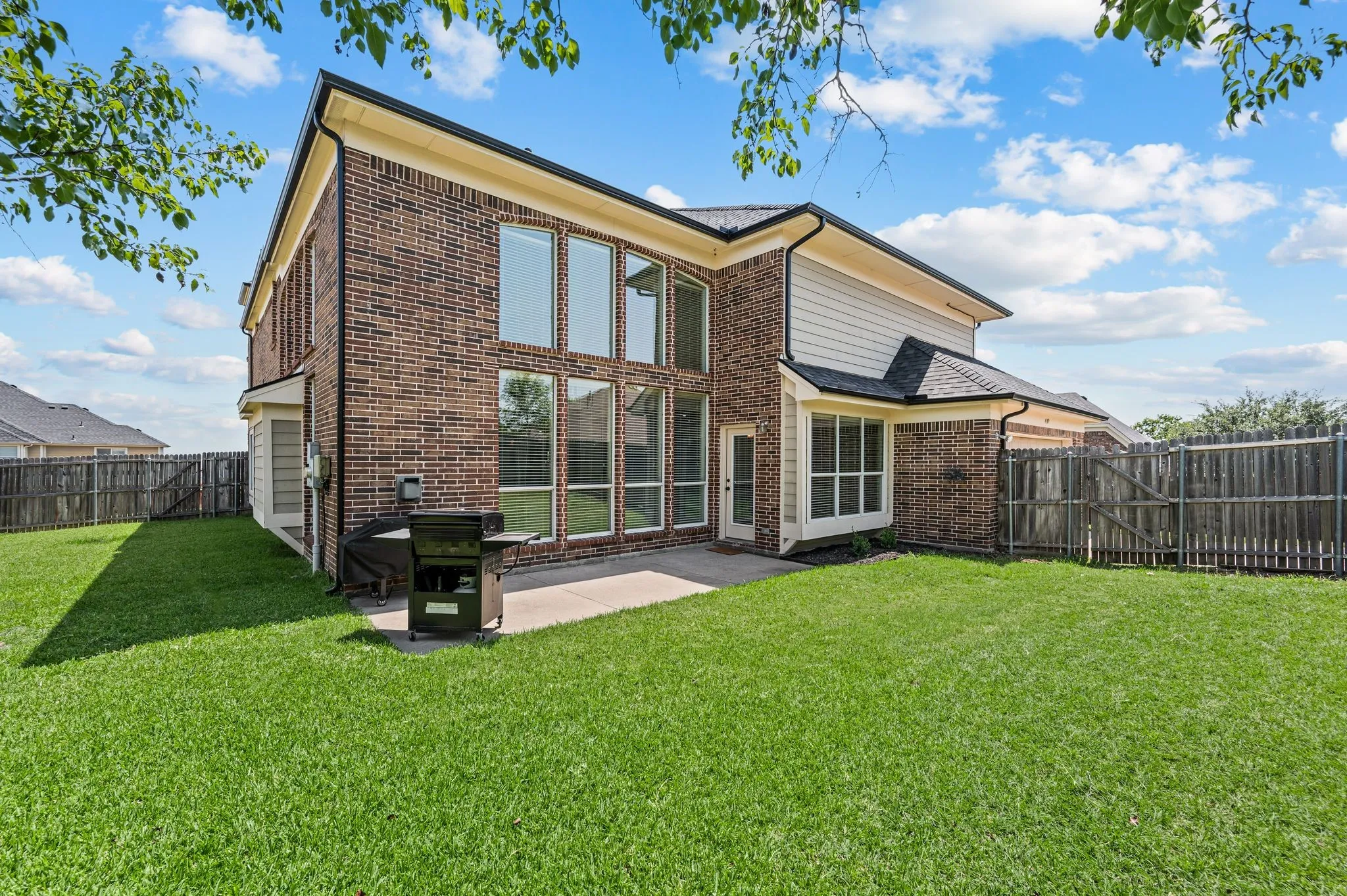 Large backyard with an extended patio offering plenty of space to relax, entertain or play.