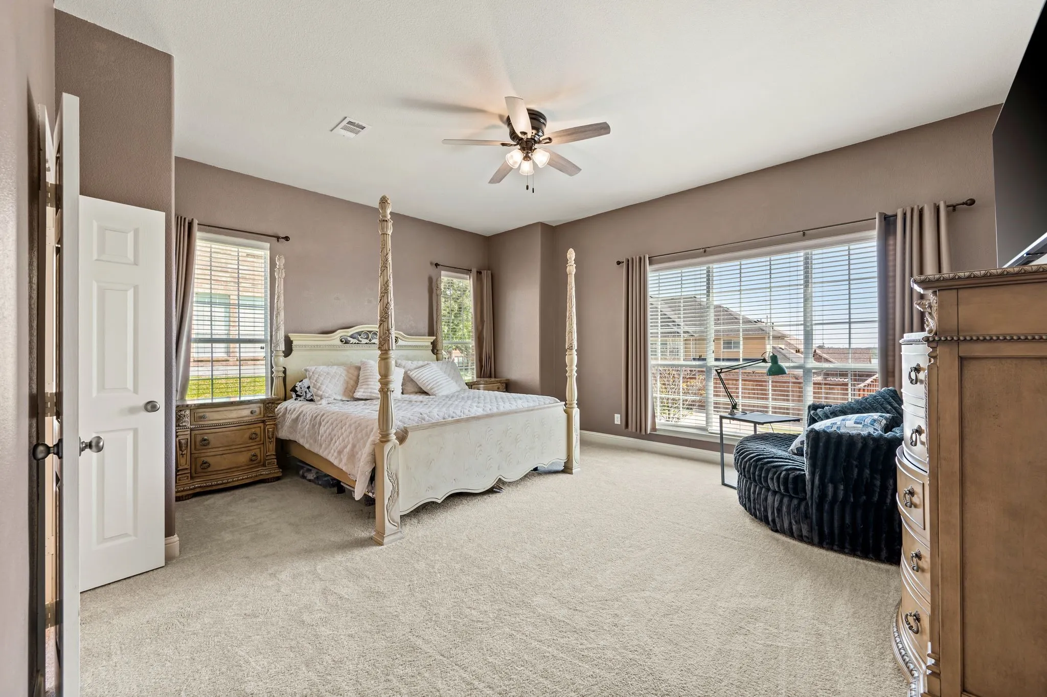 Spacious primary suite offers room for oversized furnishings & a relaxing sitting area. 10' ceilings present in this room!