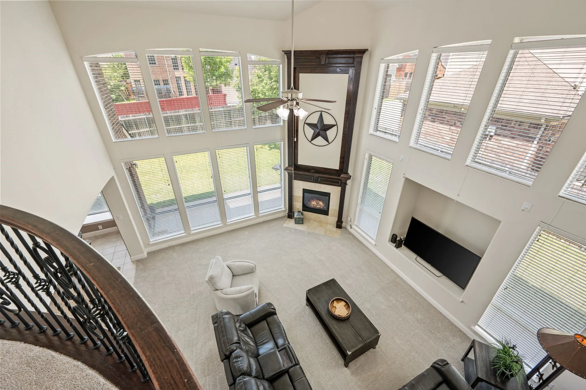 Incredible two-story family room (featuring 20' ceilings) offers floor-to-ceiling windows, a striking gas log fireplace & an abundance of natural light.