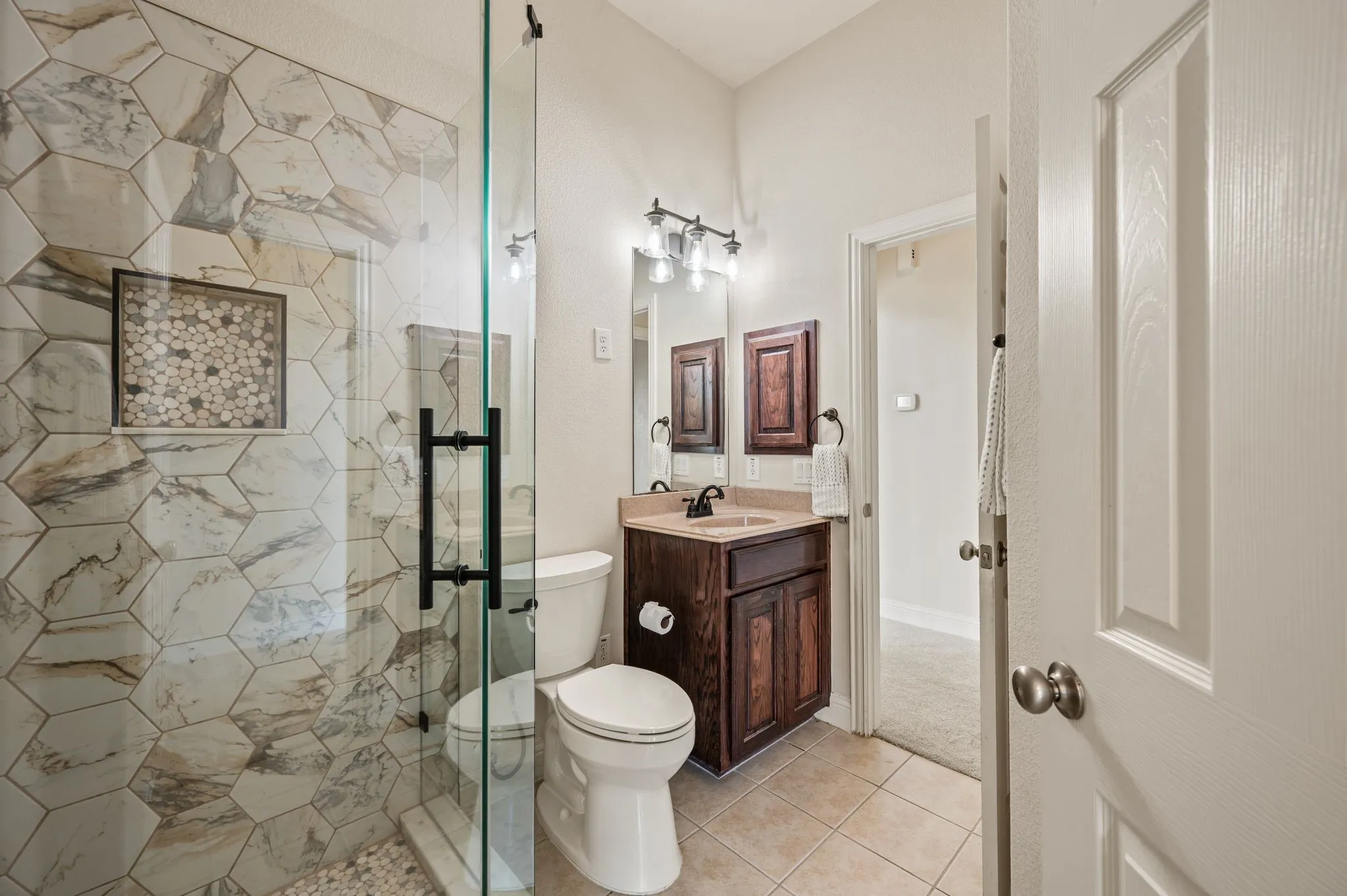 Beautifully updated downstairs secondary bathroom with a custom tiled walk-in shower that was renovated in 2025!