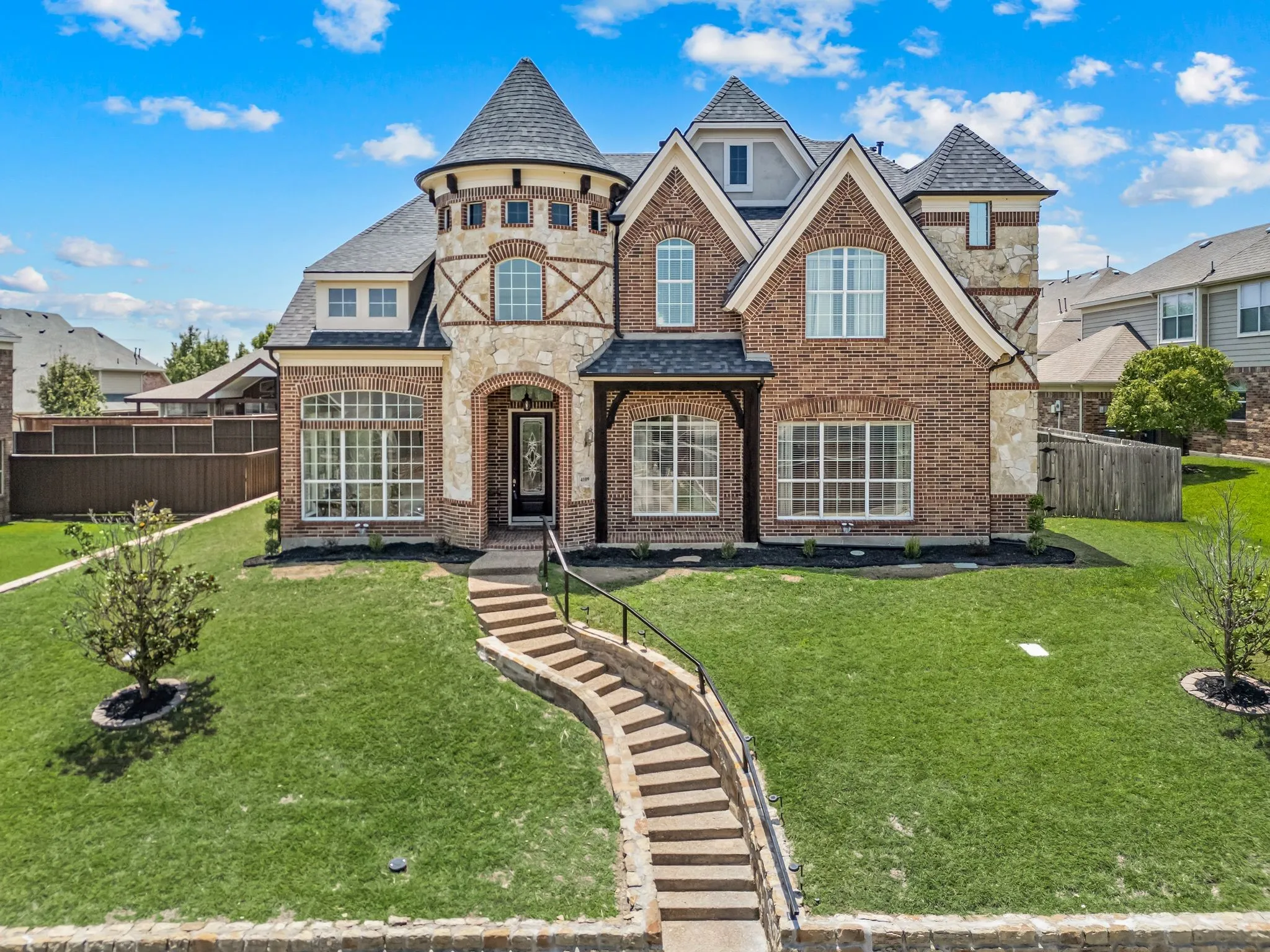Stunning curb appeal welcomes you home with timeless brick & stone architecture, elegant turret details & beautifully manicured landscaping.