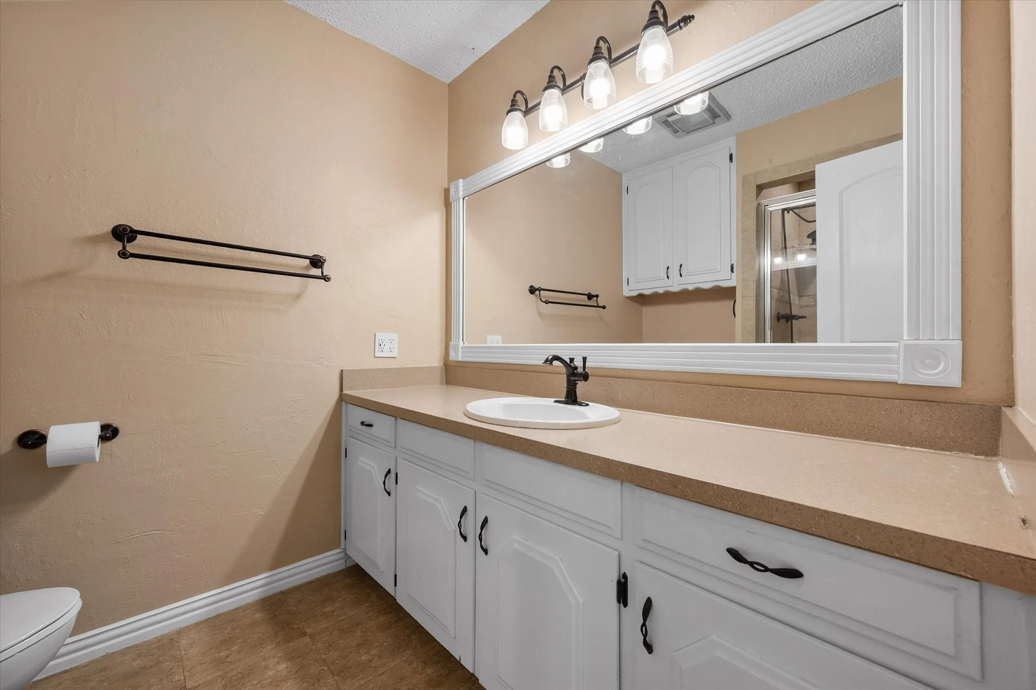 Primary bathroom has a large vanity and stand in shower