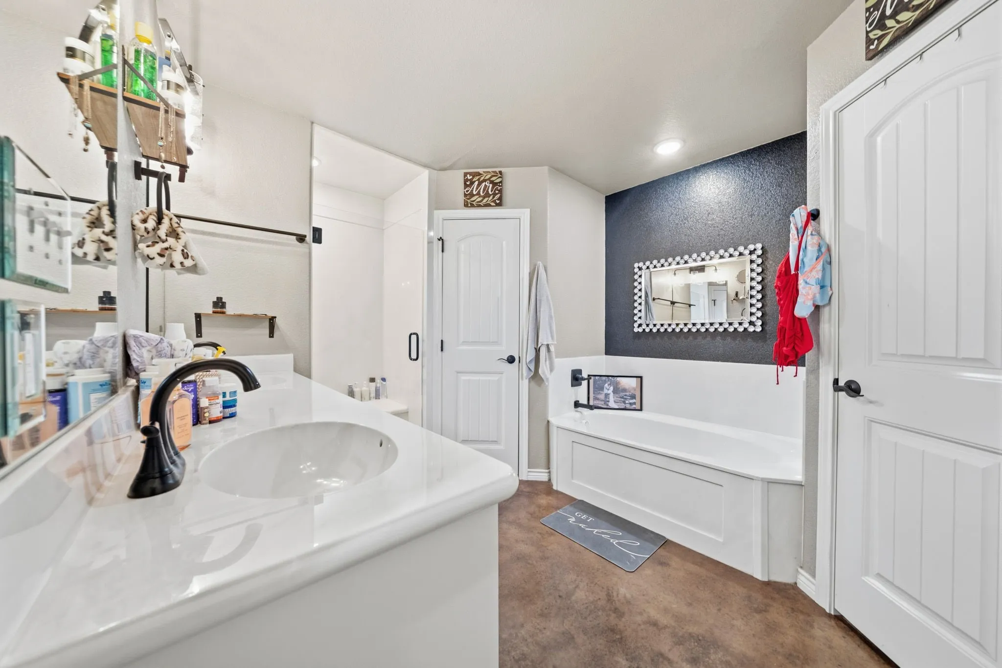 Dual sinks in primary bathroom with 2 walk in closets, soaking tub, and separate shower.
