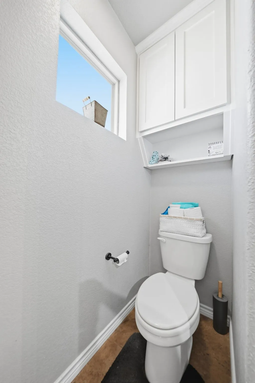 Primary bathroom suite with window and built in storage cabinetry.