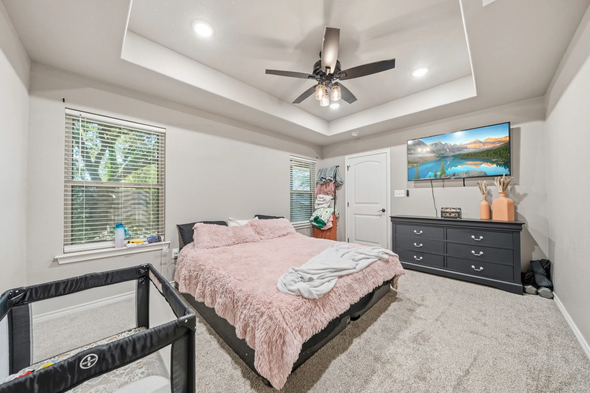 Primary bedroom with boxed ceilings and walk in closets