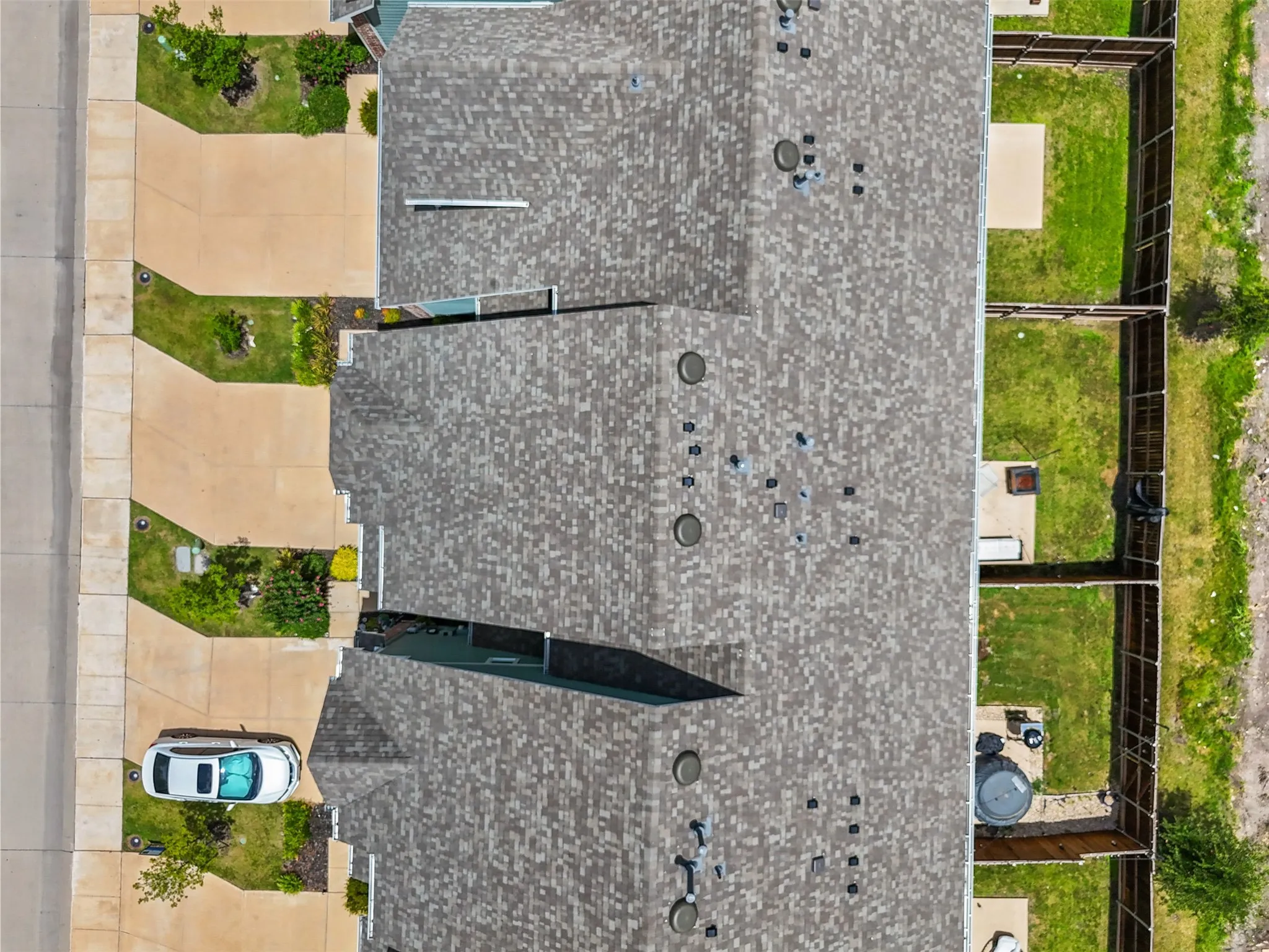 Aerial perspective showcasing multiple properties with shingle roofing and private backyard spaces