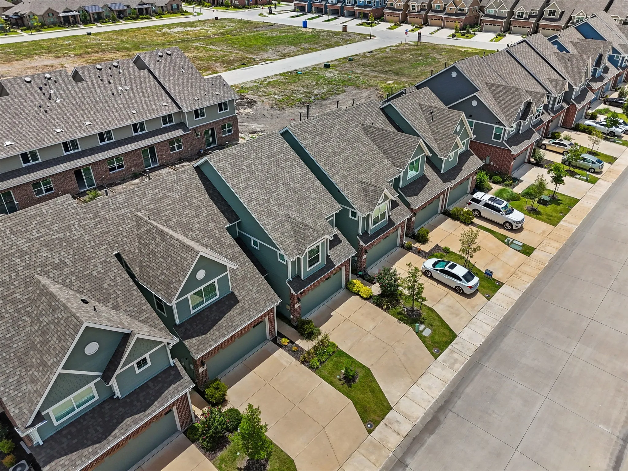 Row of modern townhomes featuring gabled roofs and individual driveways