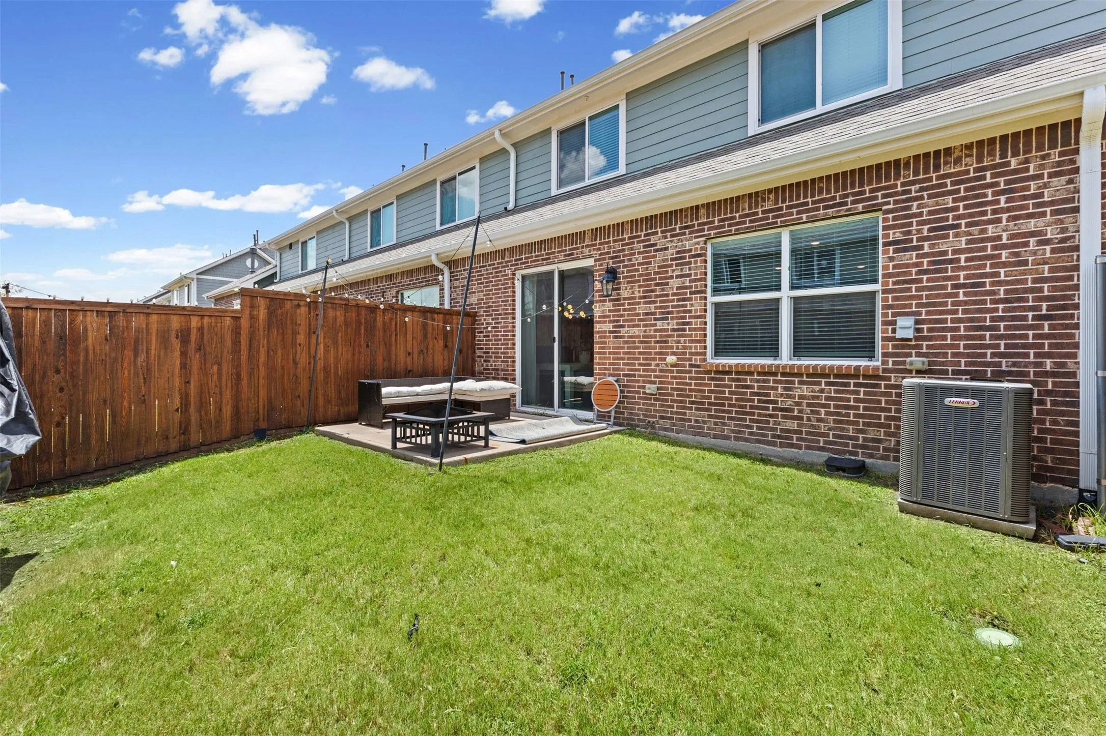 Private backyard featuring a manicured lawn, a concrete patio, and a wood privacy fence