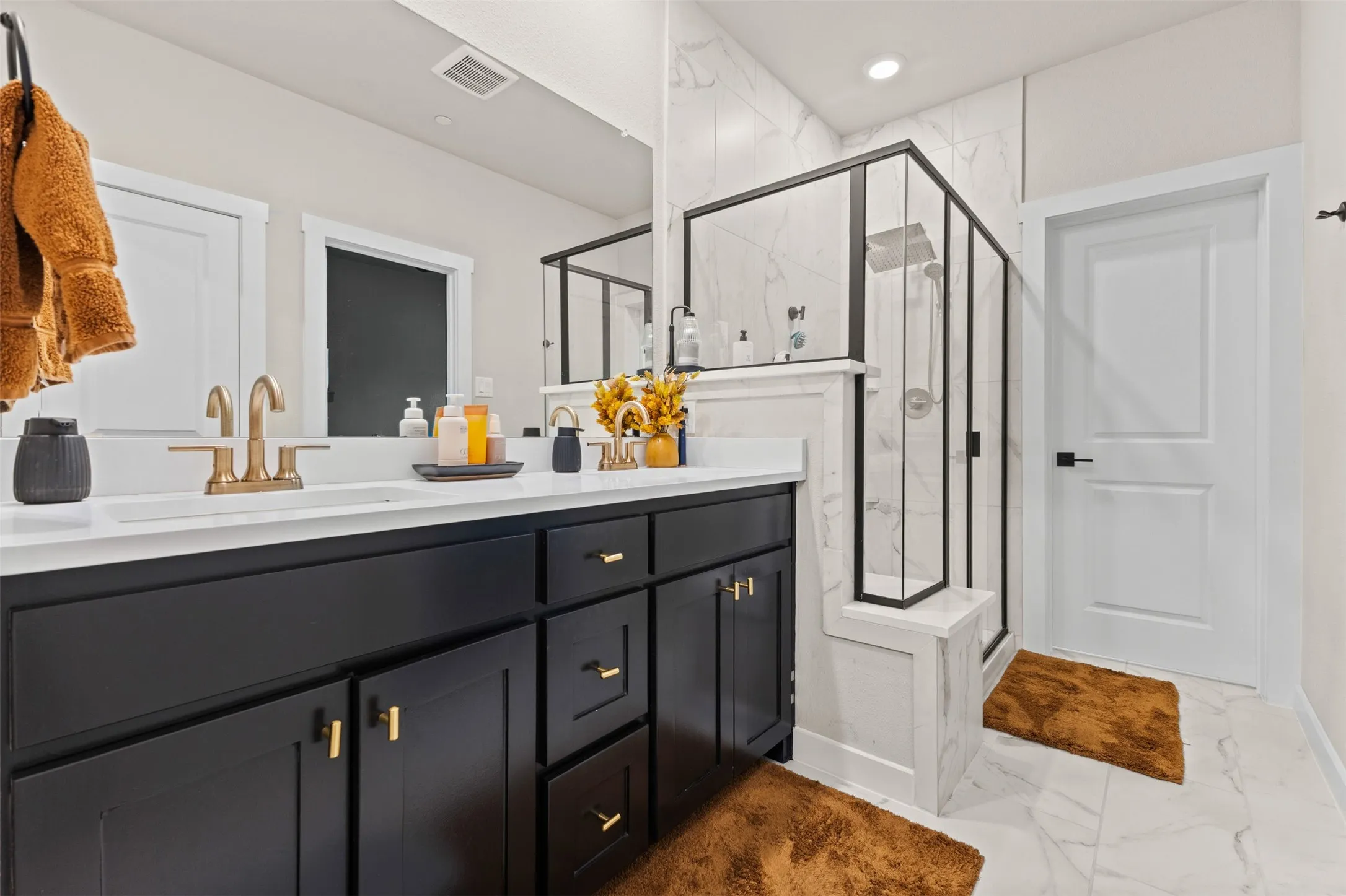 Dual-sink vanity with matte black cabinetry and gold-finish hardware