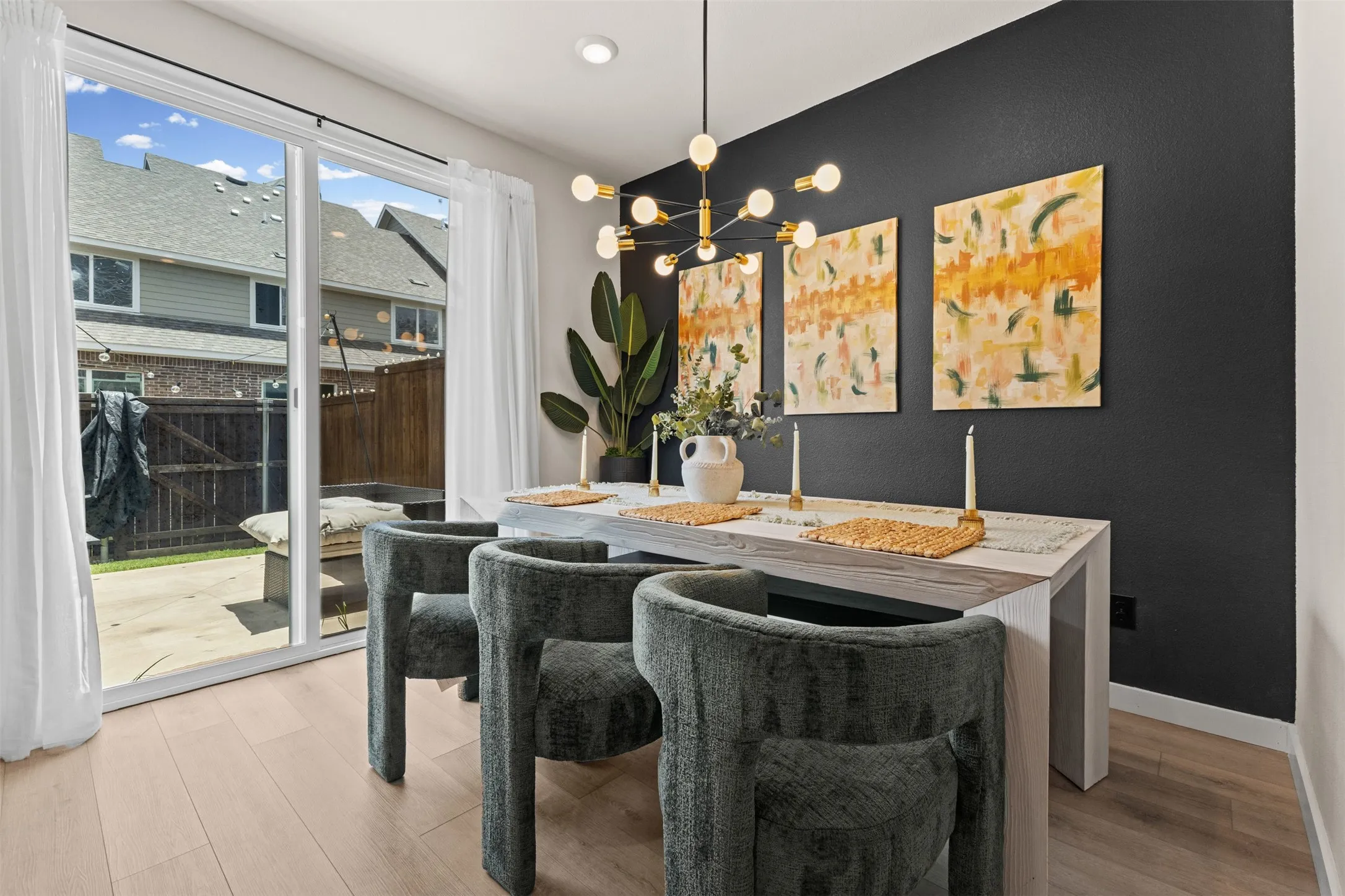 Dining area featuring light wood-finish flooring and a contemporary chandelier