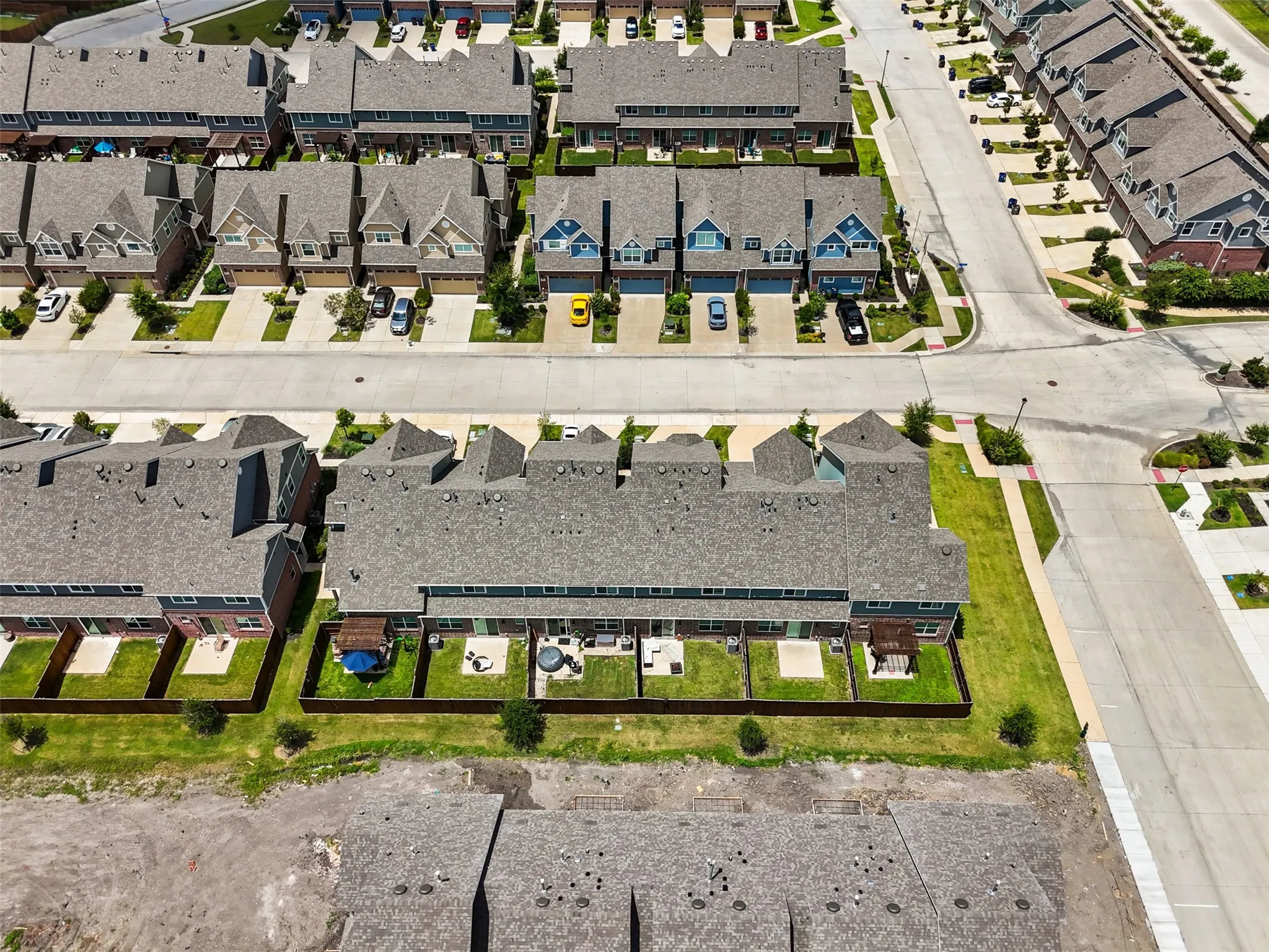Aerial view showcasing multiple residential units with private fenced backyards
