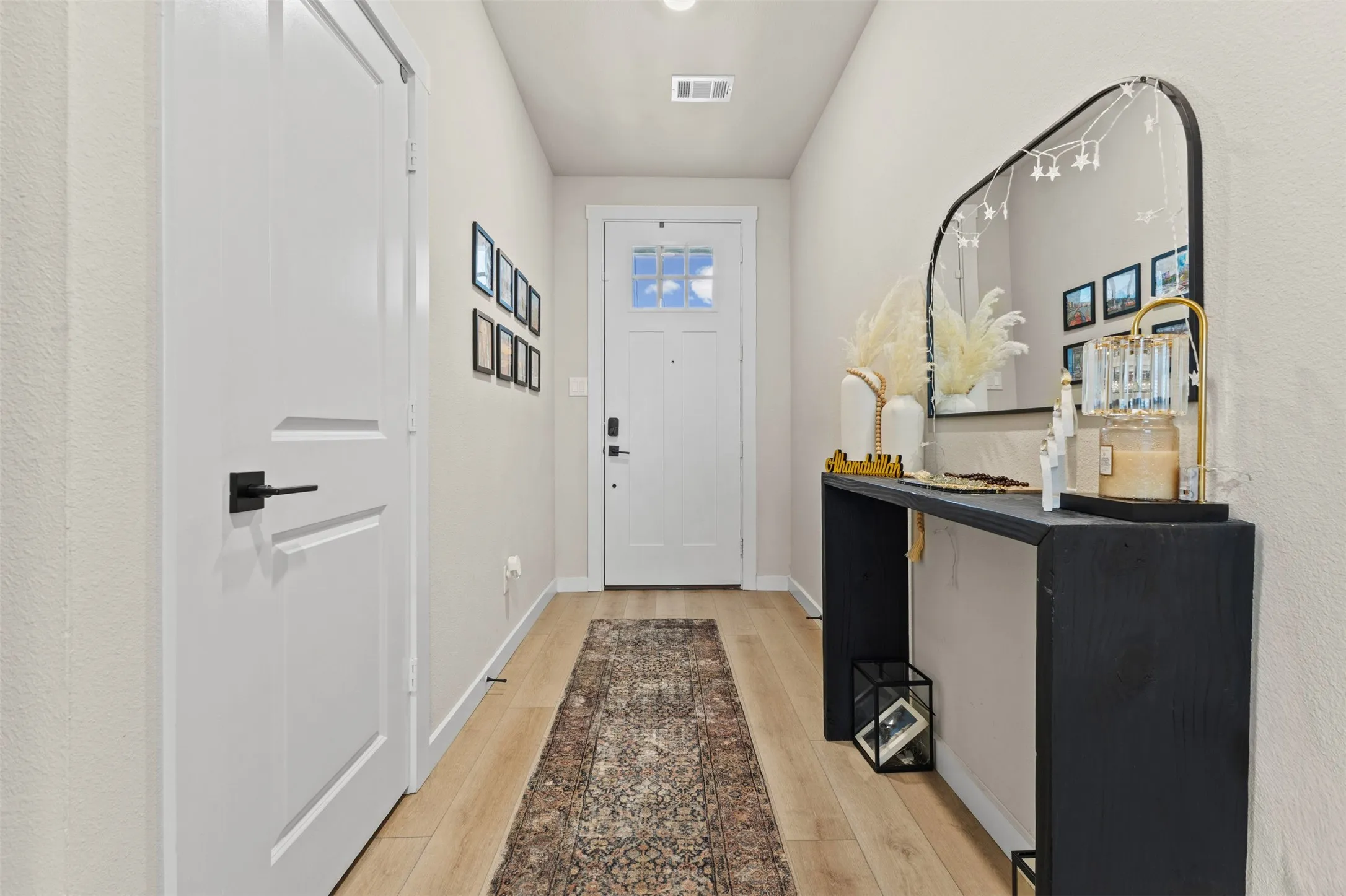 Light wood-finish flooring extending through the entry hall