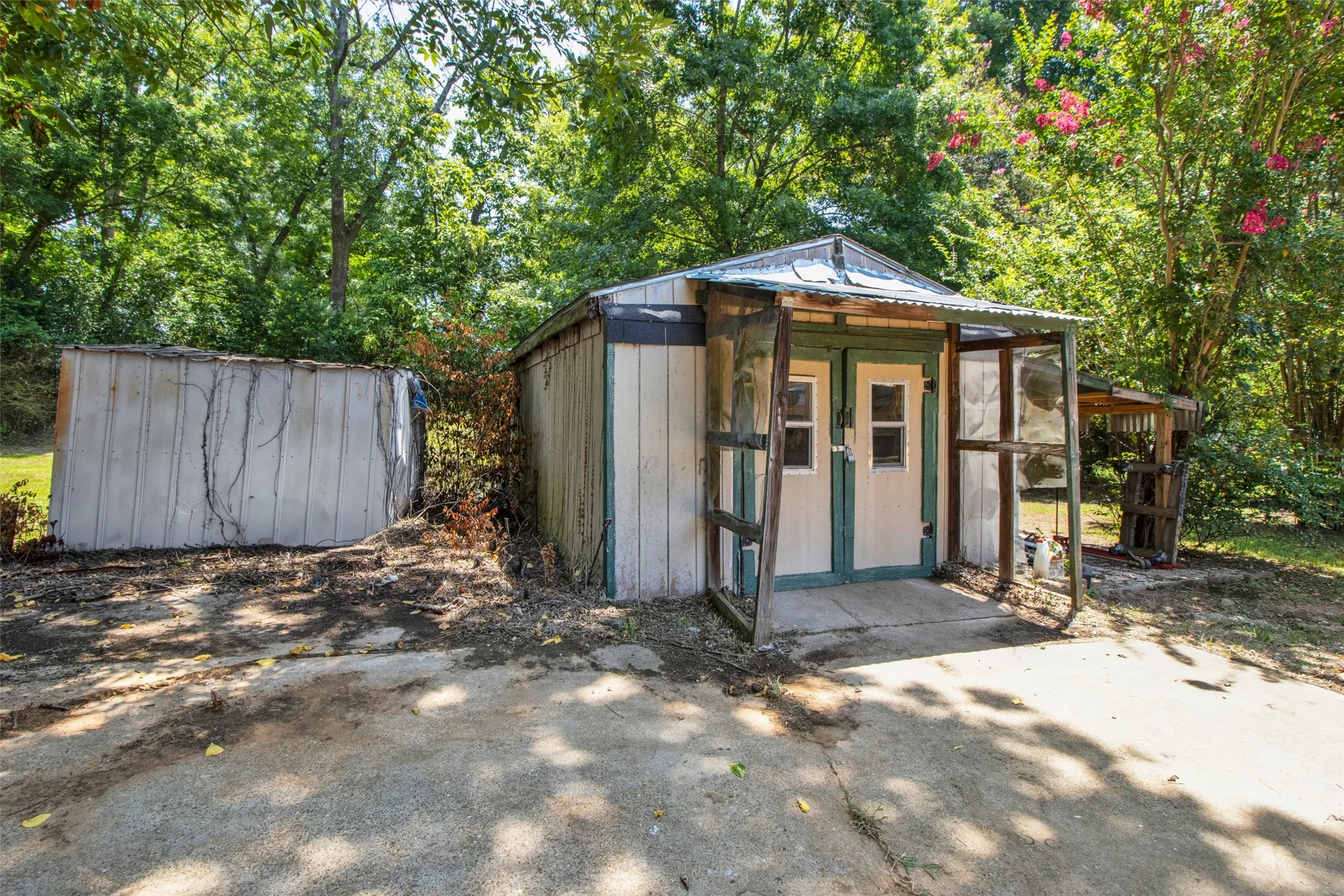 Two detached storage structures with wood panel siding