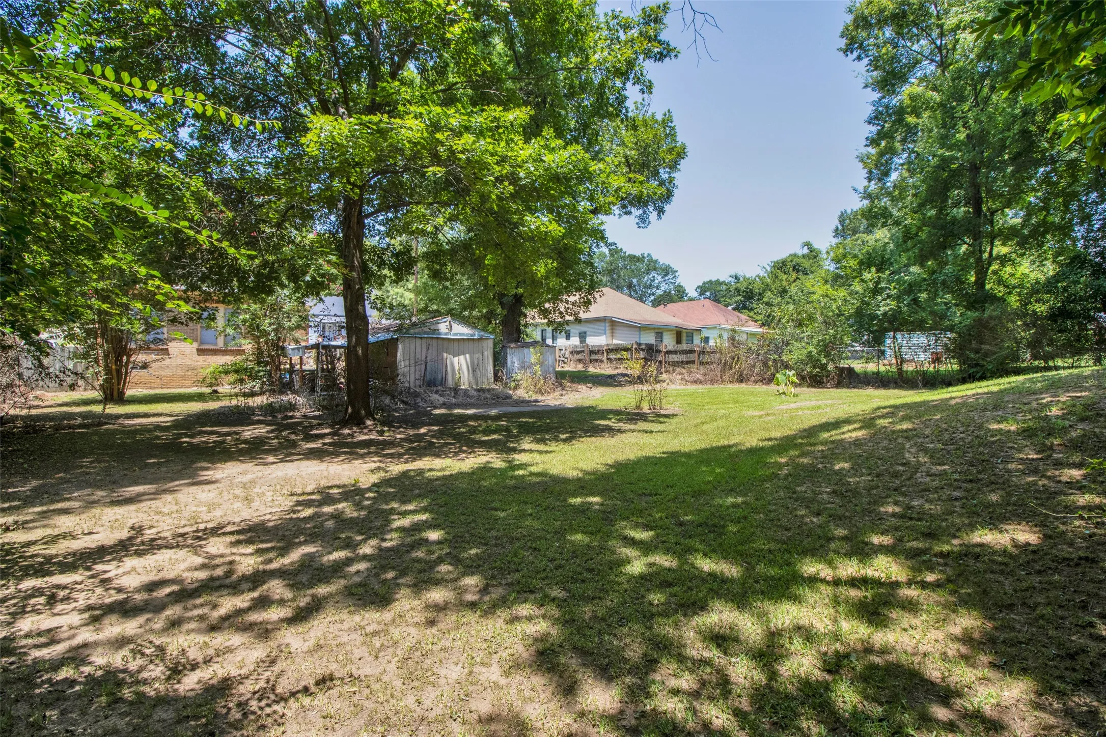 Expansive lawn featuring mature trees providing natural shading