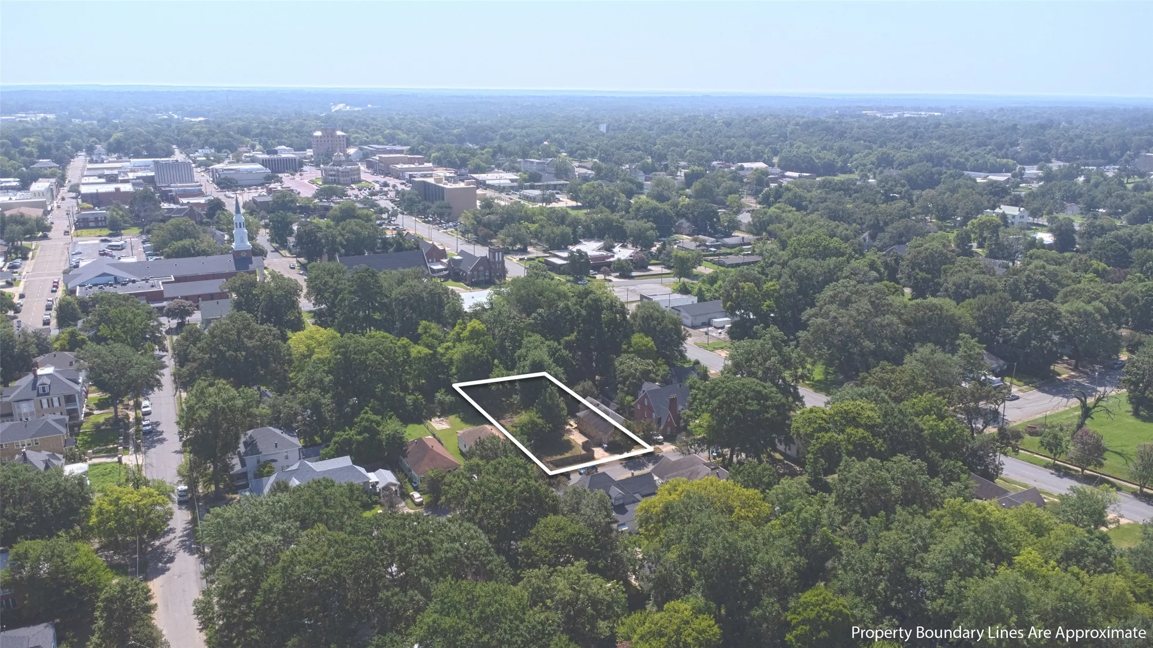 Aerial perspective showcasing a residential property within a tree-lined neighborhood