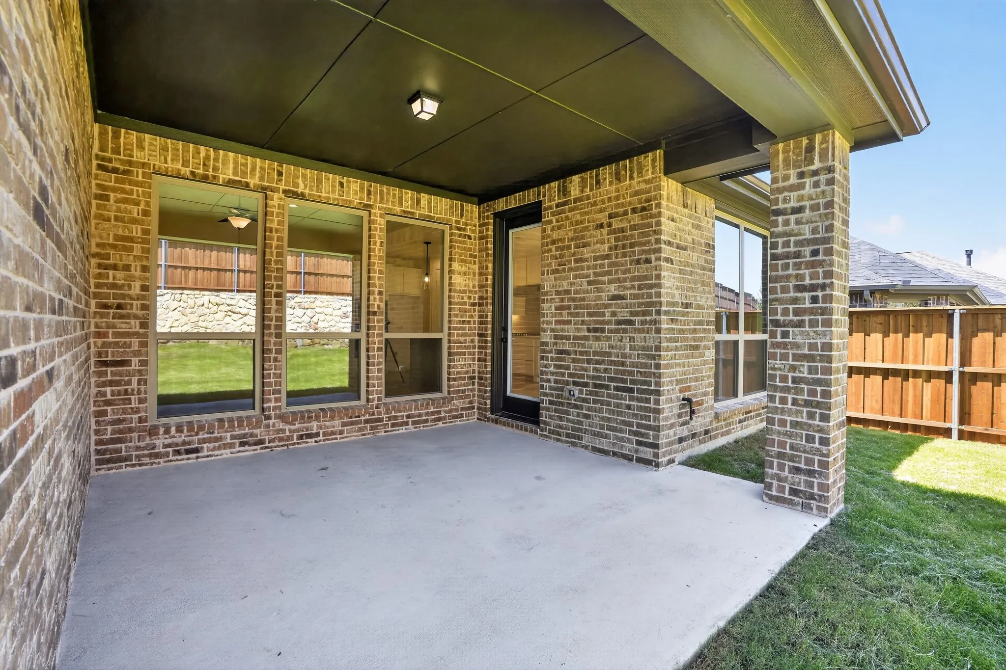 Covered patio with brick columns, concrete flooring, and a flat panel ceiling
