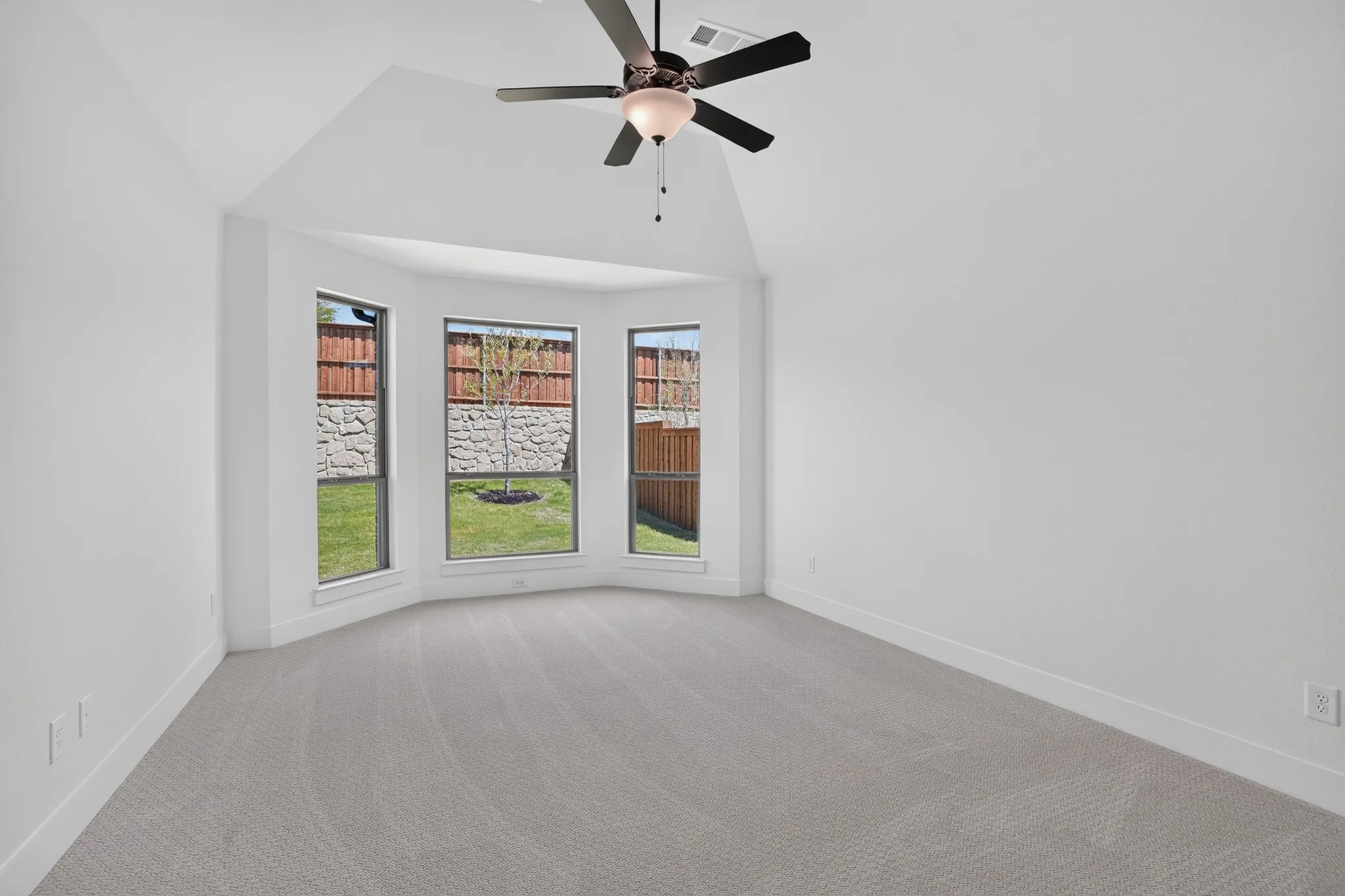 Bay window with a deep sill, vaulted ceiling, and ceiling fan