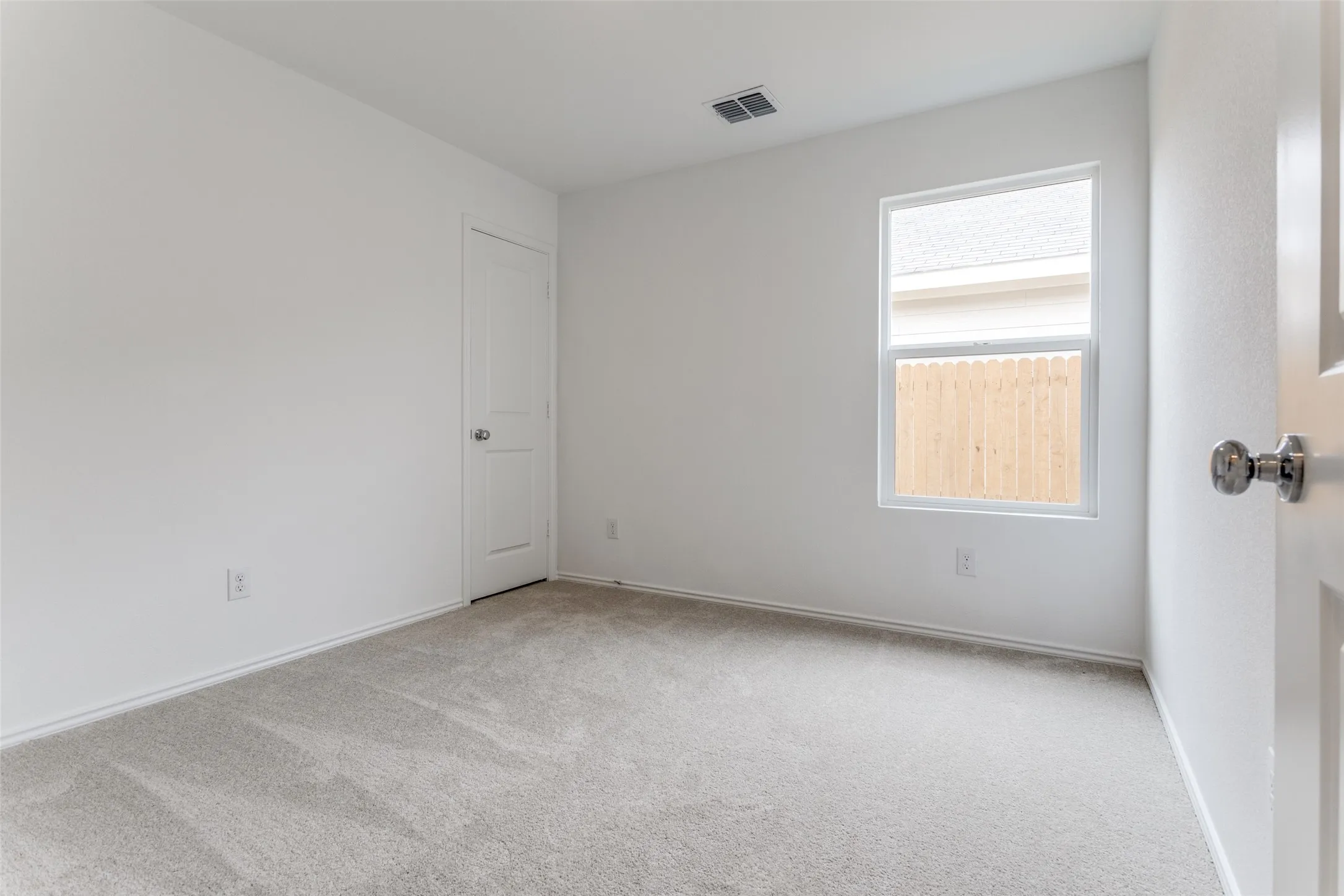 Empty room featuring a healthy amount of sunlight and carpet flooring