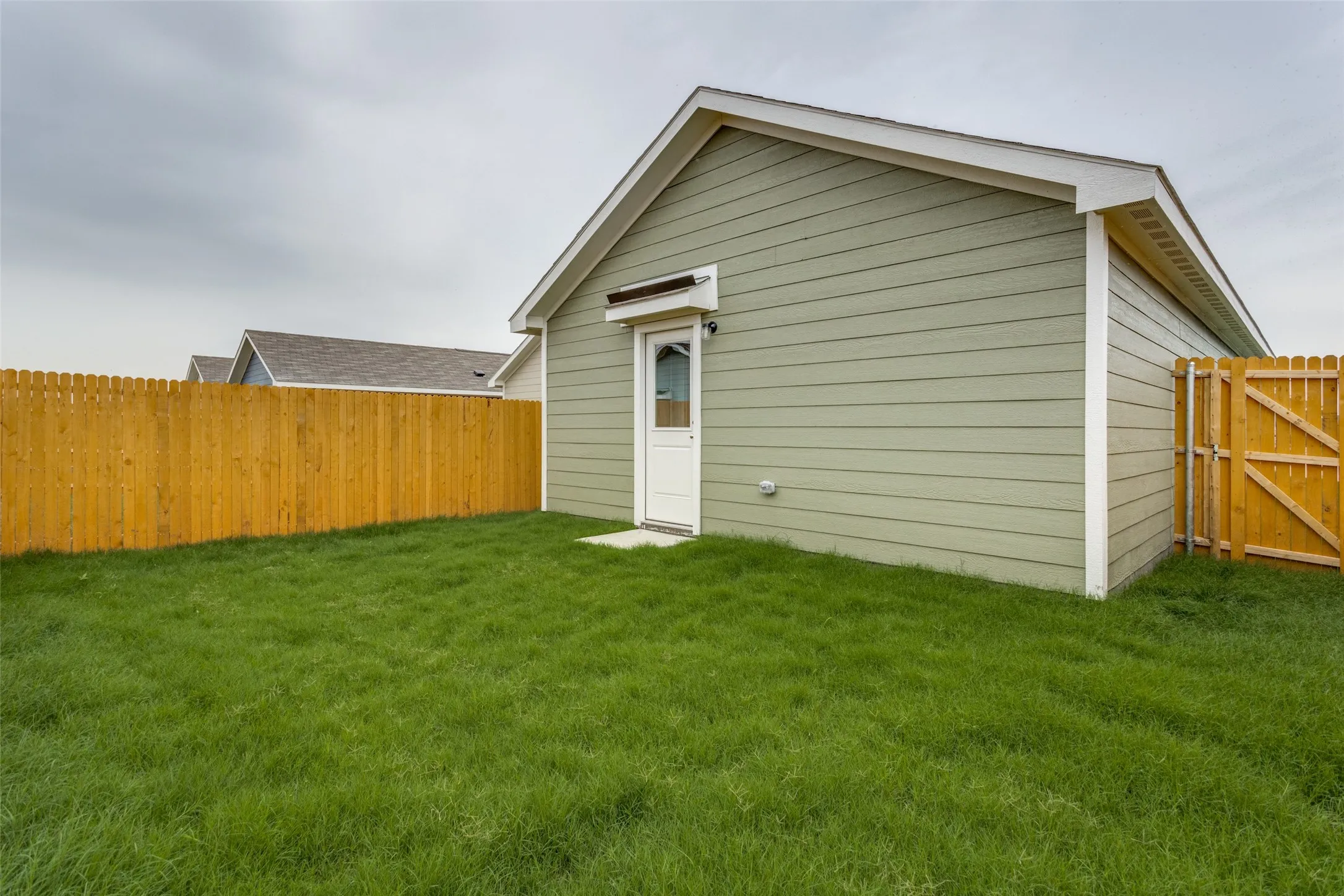 Back of property with a lawn