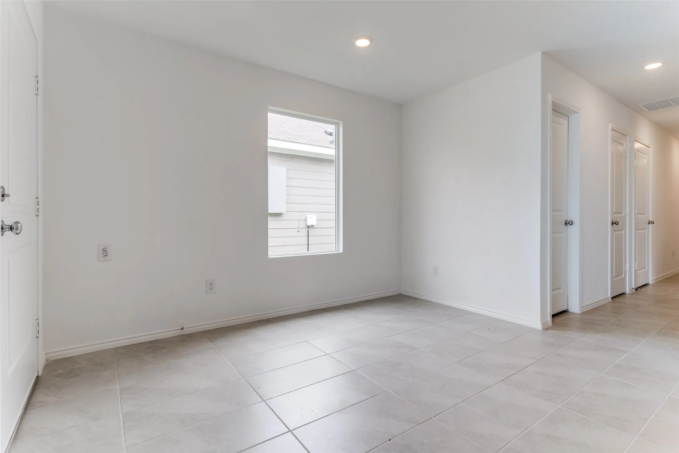 Empty room with light tile flooring