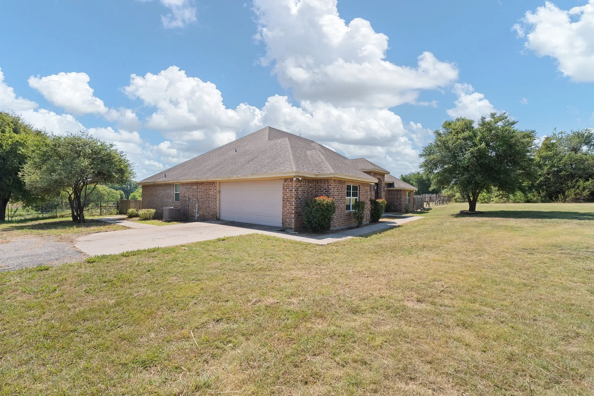 Brick exterior residence with a shingled roof, featuring an attached garage with a solid door