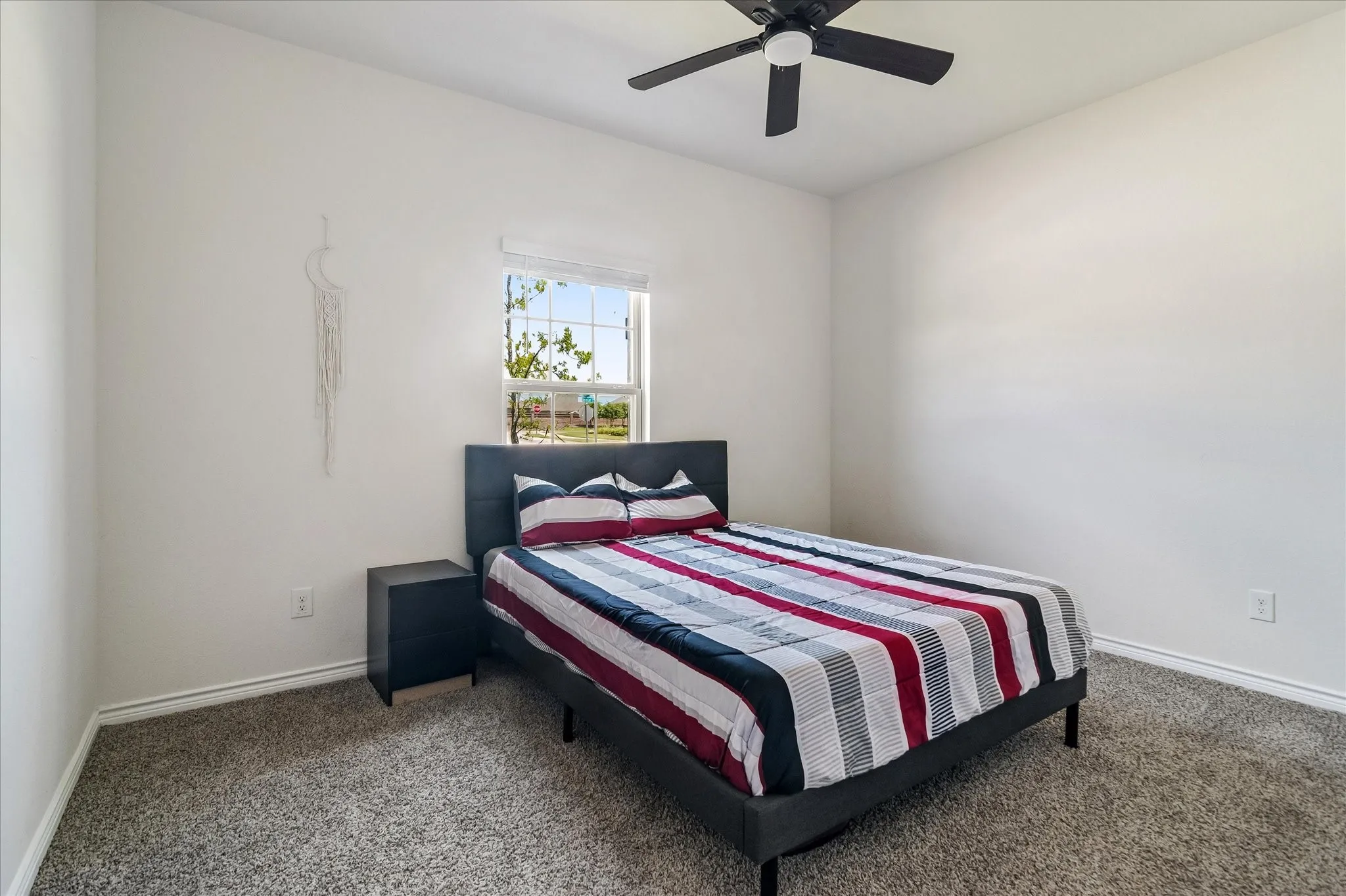 Carpeted room featuring a ceiling fan, a window with blinds, and white wall finishes
