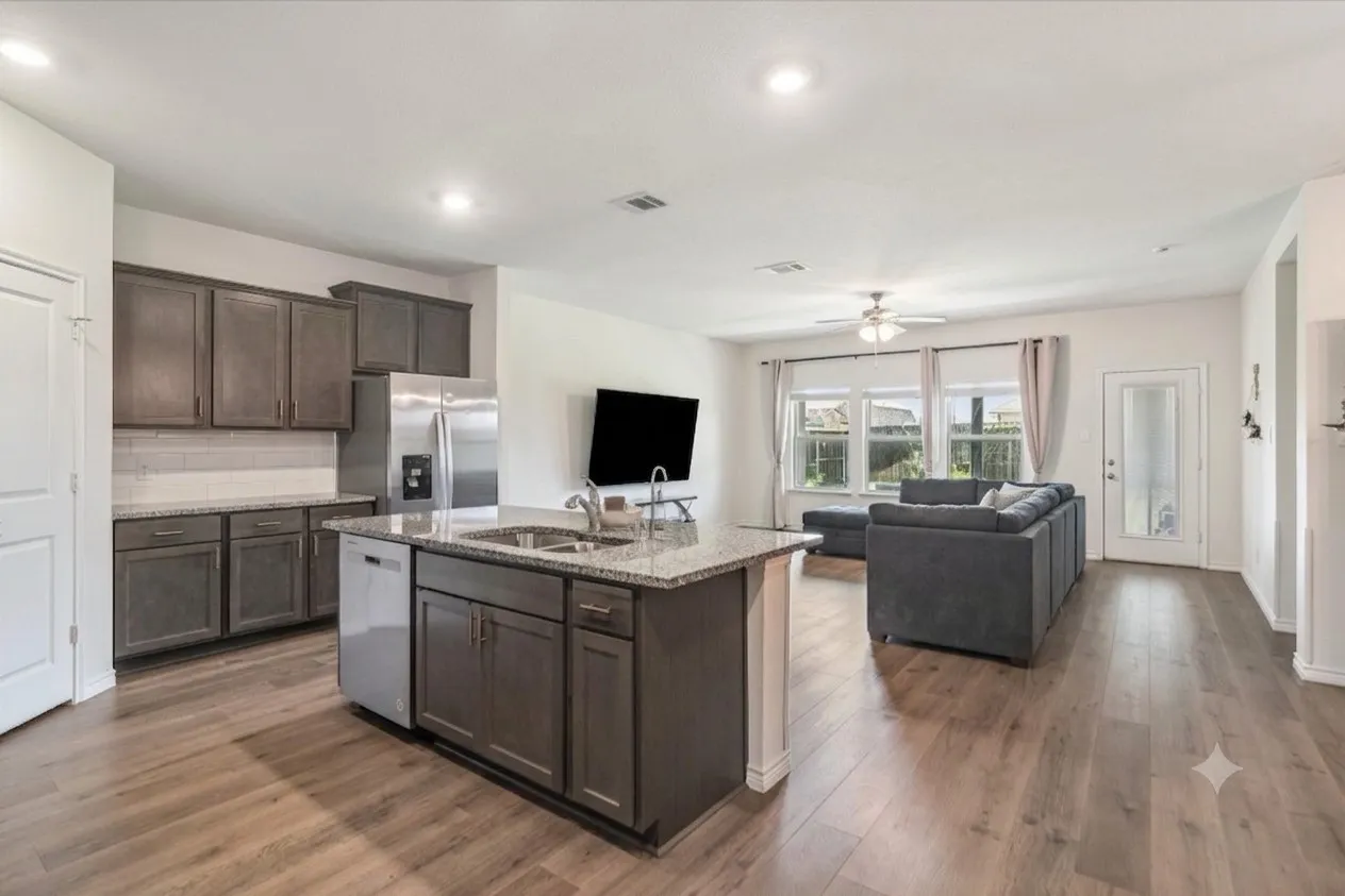 Open-concept living space featuring wood-finish flooring, recessed lighting, and a ceiling fan