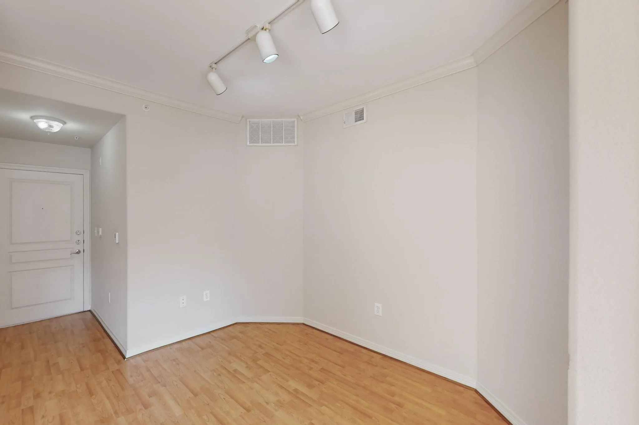 Unfurnished room with track lighting, light wood-style floors, and ornamental molding