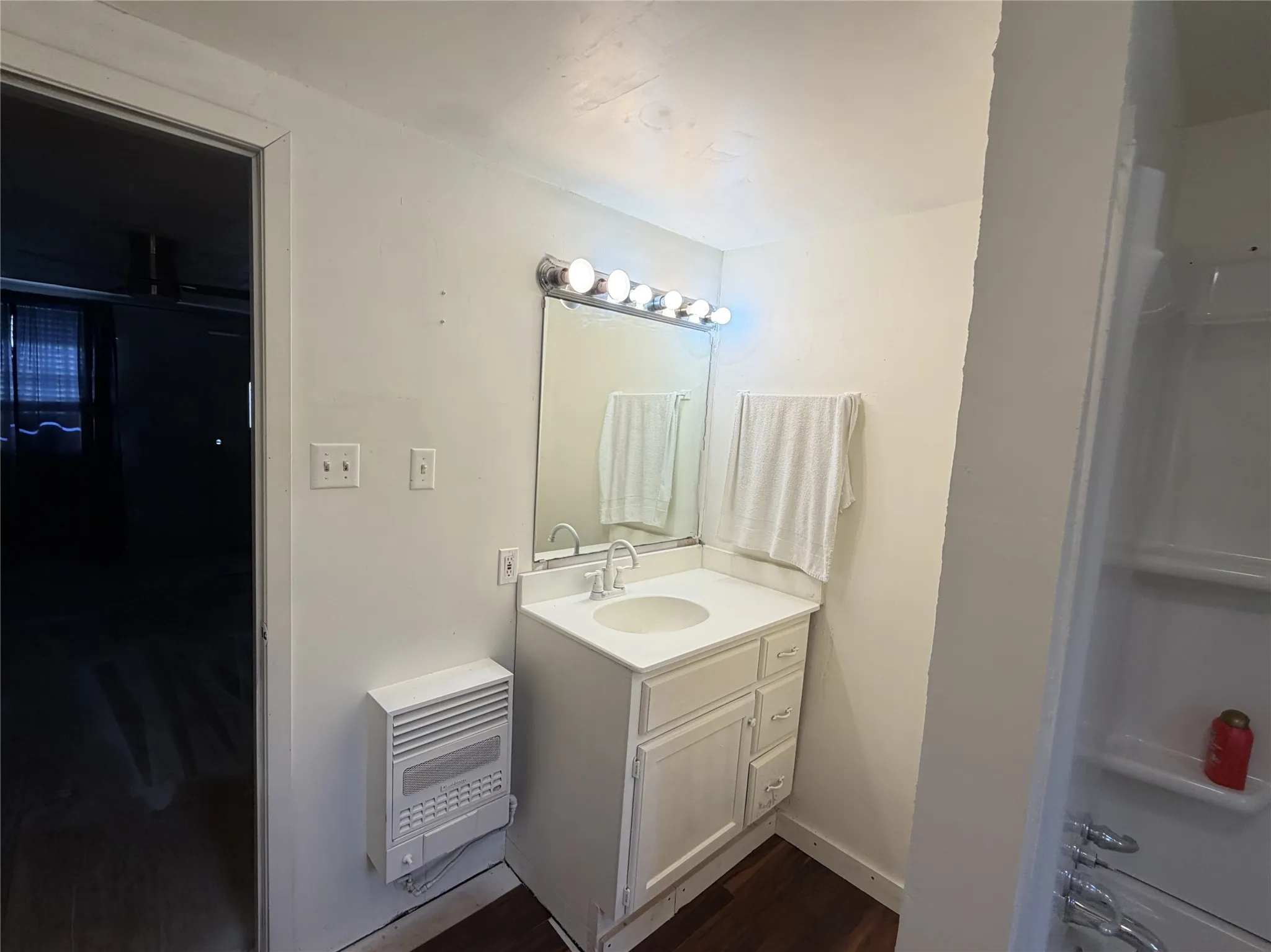 Bathroom with white vanity, integrated sink, and fixtures