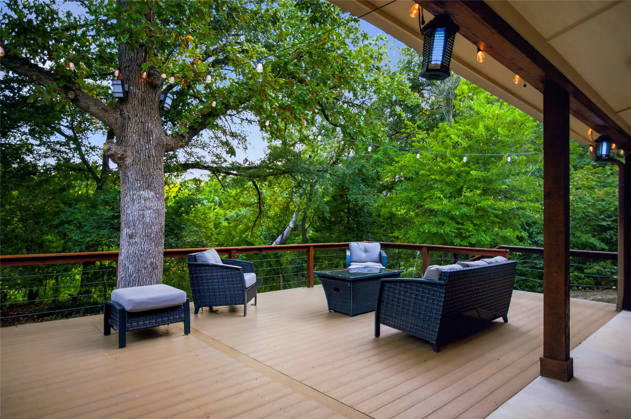 The deck looks out to a wooded path.