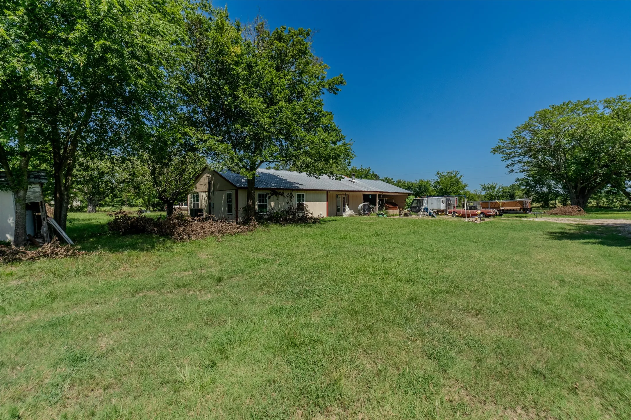 Expansive green lawn with mature trees providing natural shade