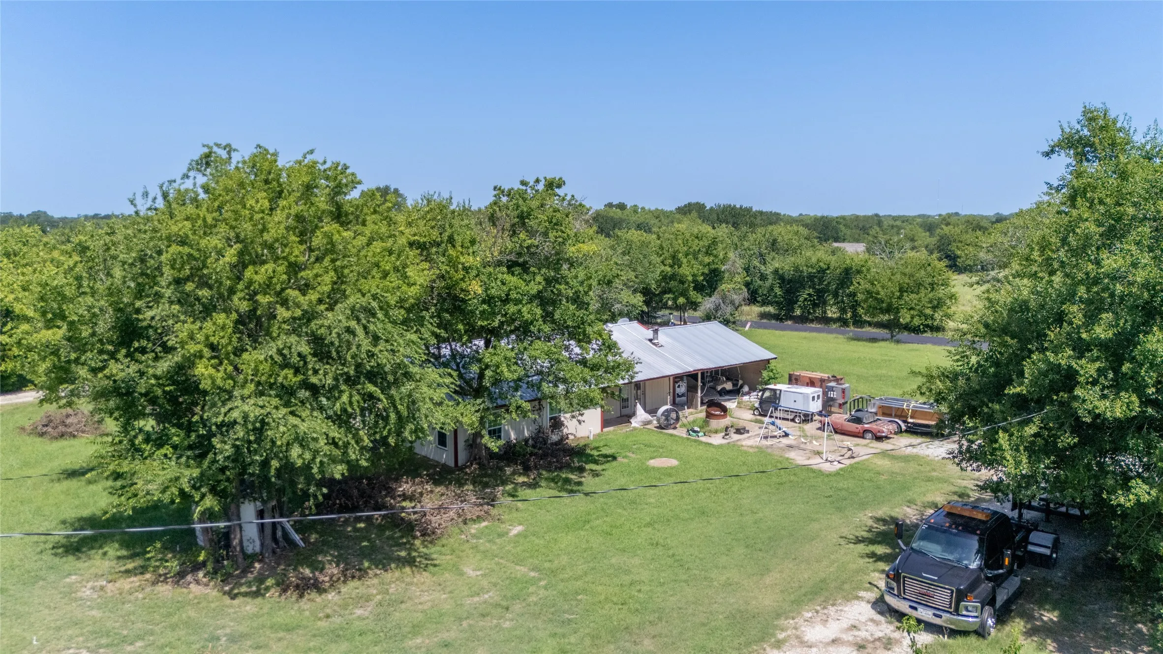 Rural property featuring a single-story residence with a metal roof and an extended covered porch